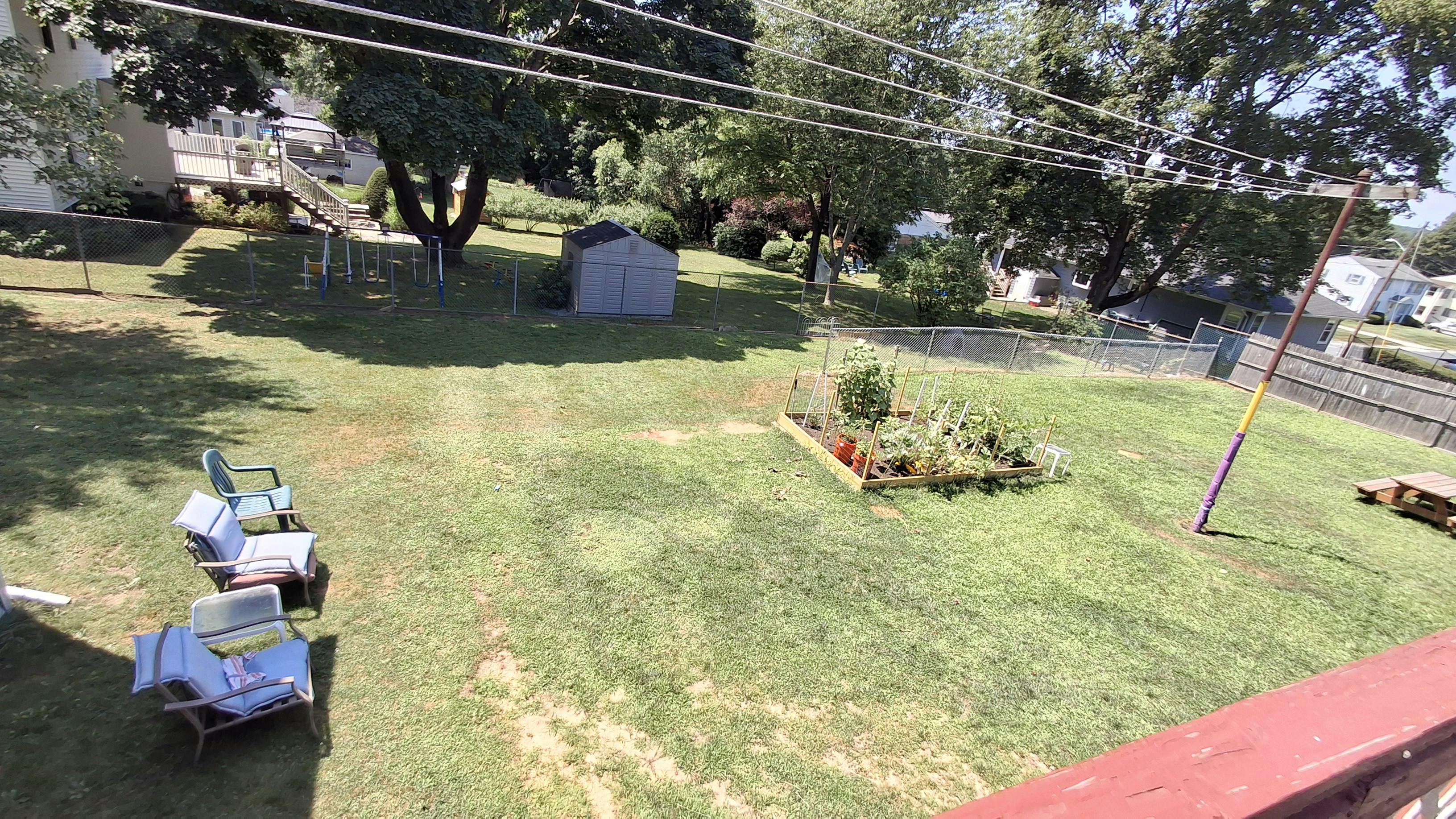 Backyard with a garden bed, shed, and chairs