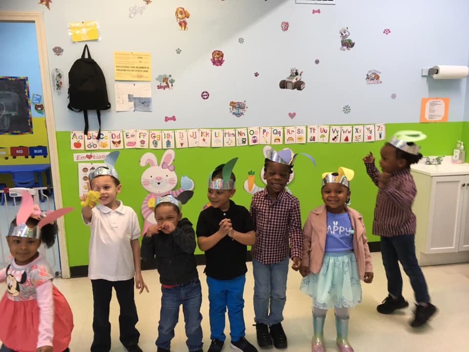 Children wearing paper hats in a classroom