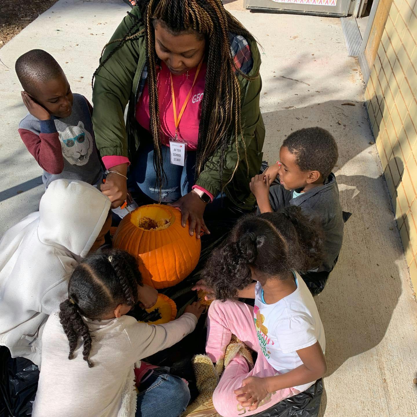Person and children carving a pumpkin