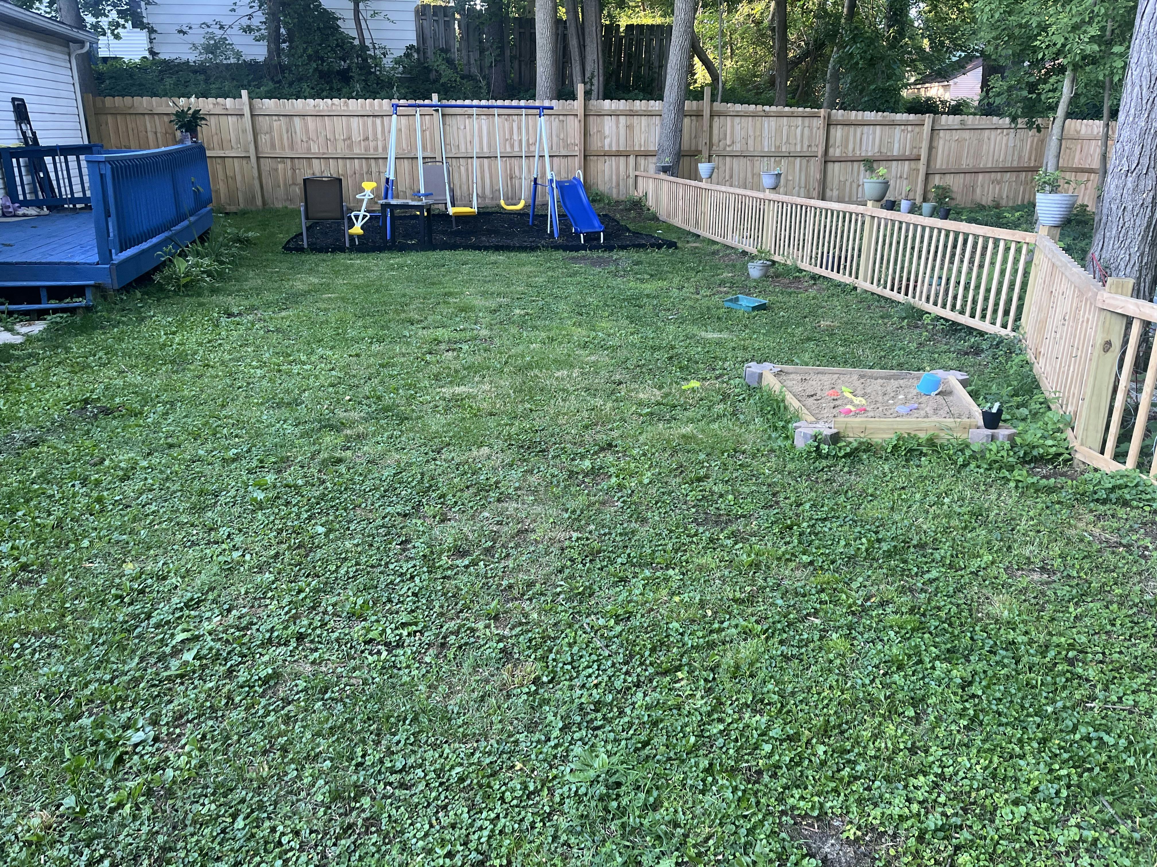 Backyard with a swing set and a sandbox