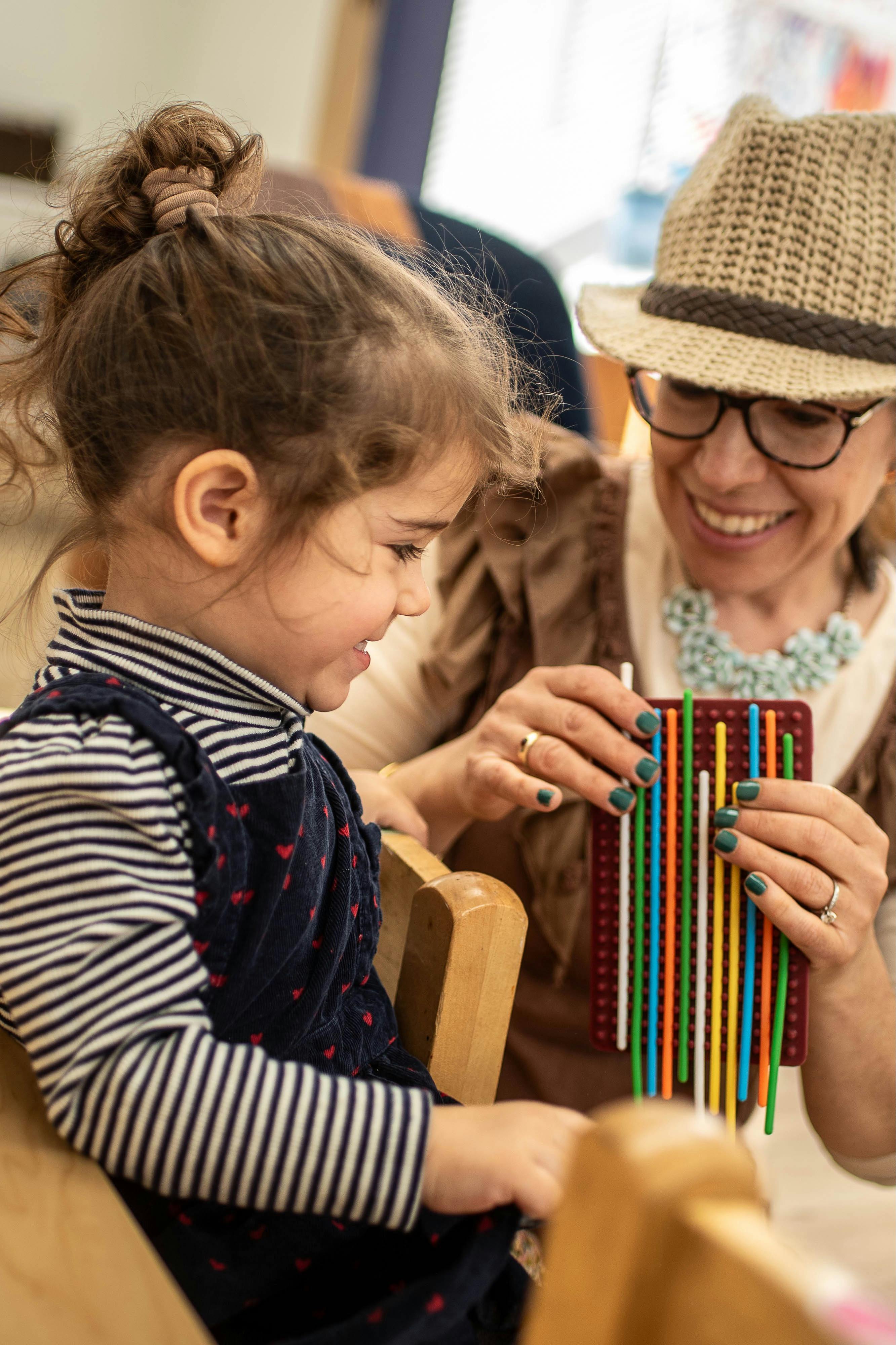 Adult and child playing with a colorful stick toy