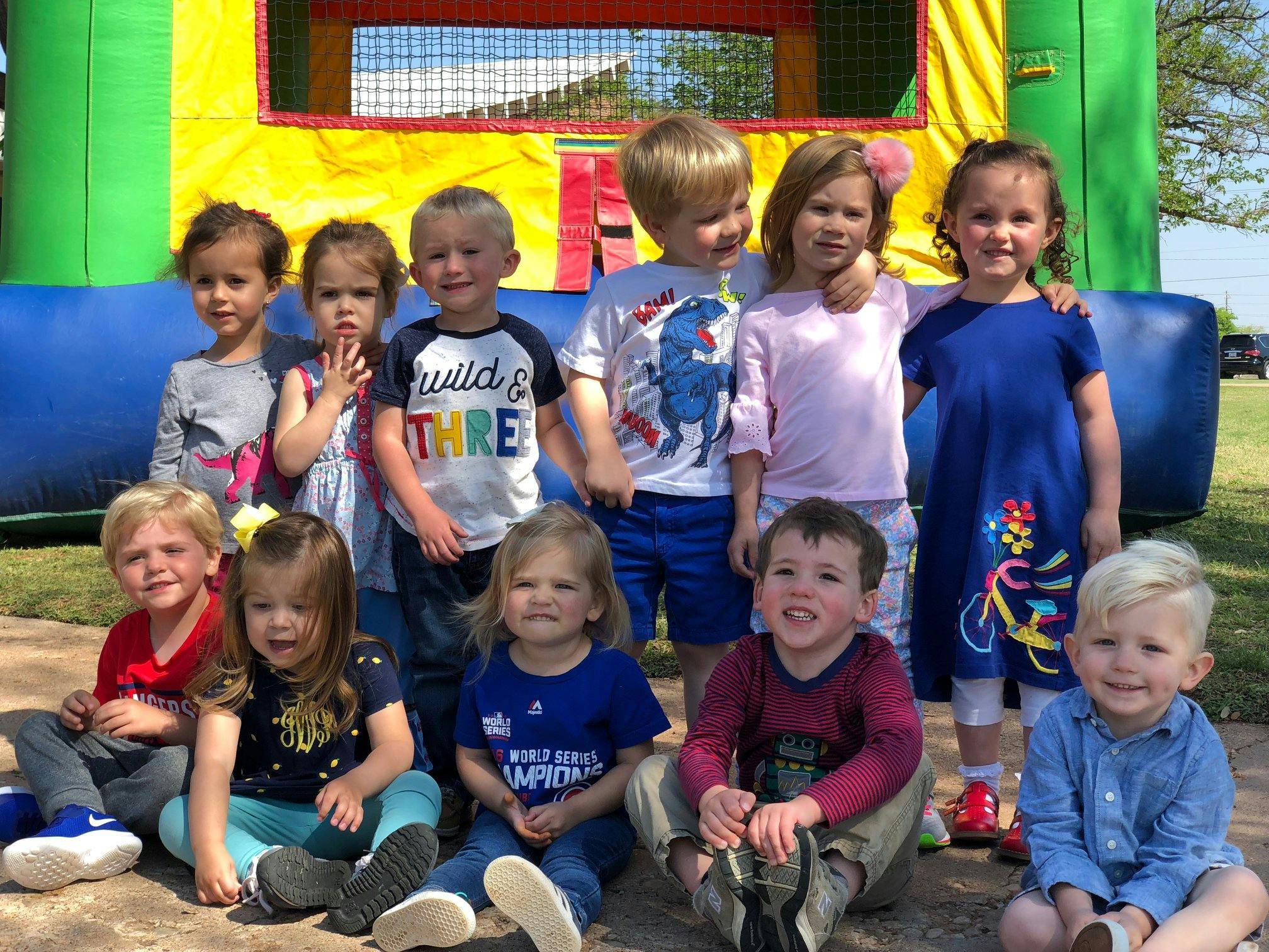 Group of children posing in front of an inflatable bounce house