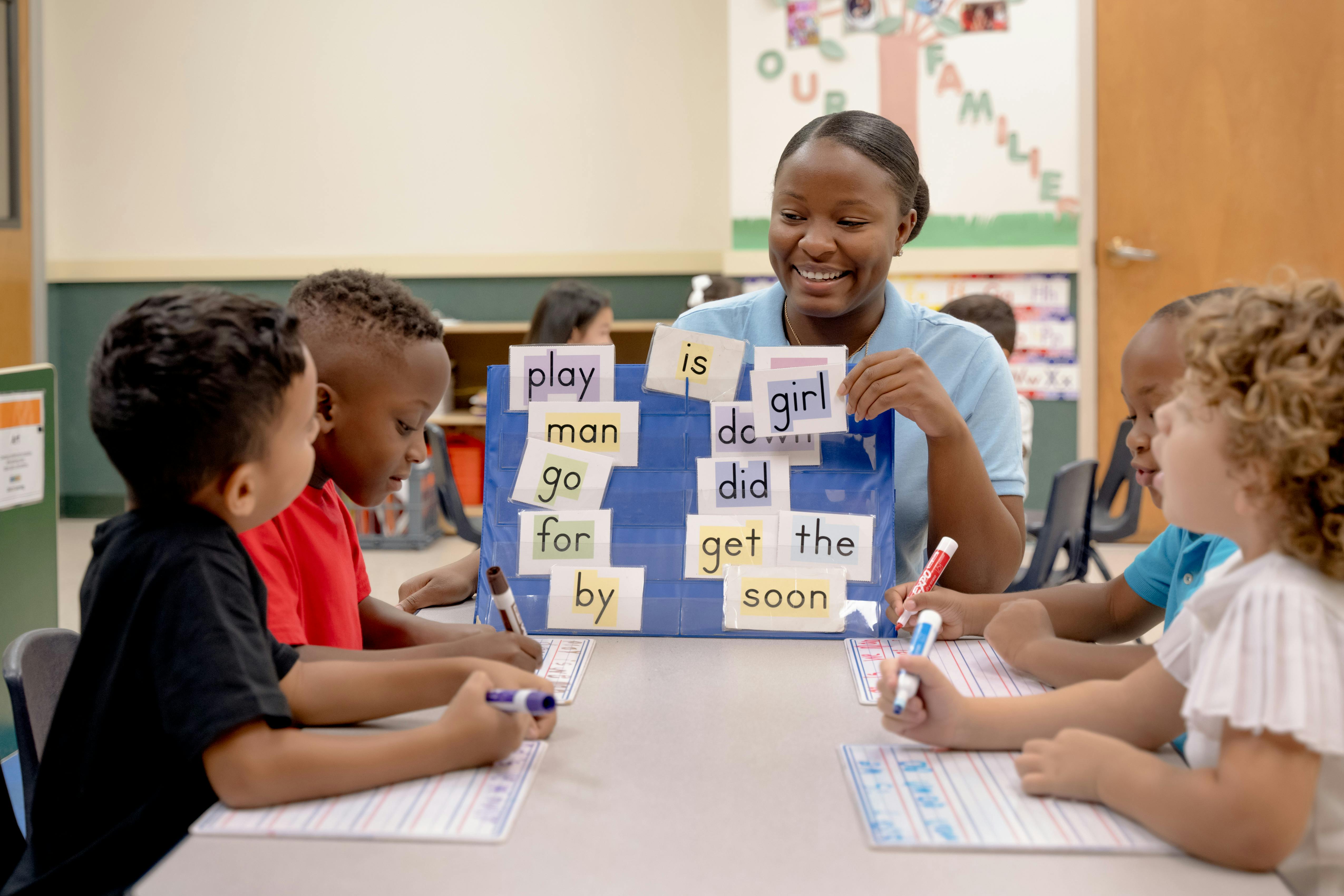 Adult teaching children with word cards in a classroom