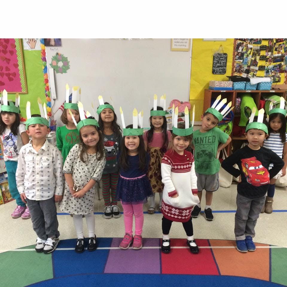 Group of children wearing green headbands with white feathers
