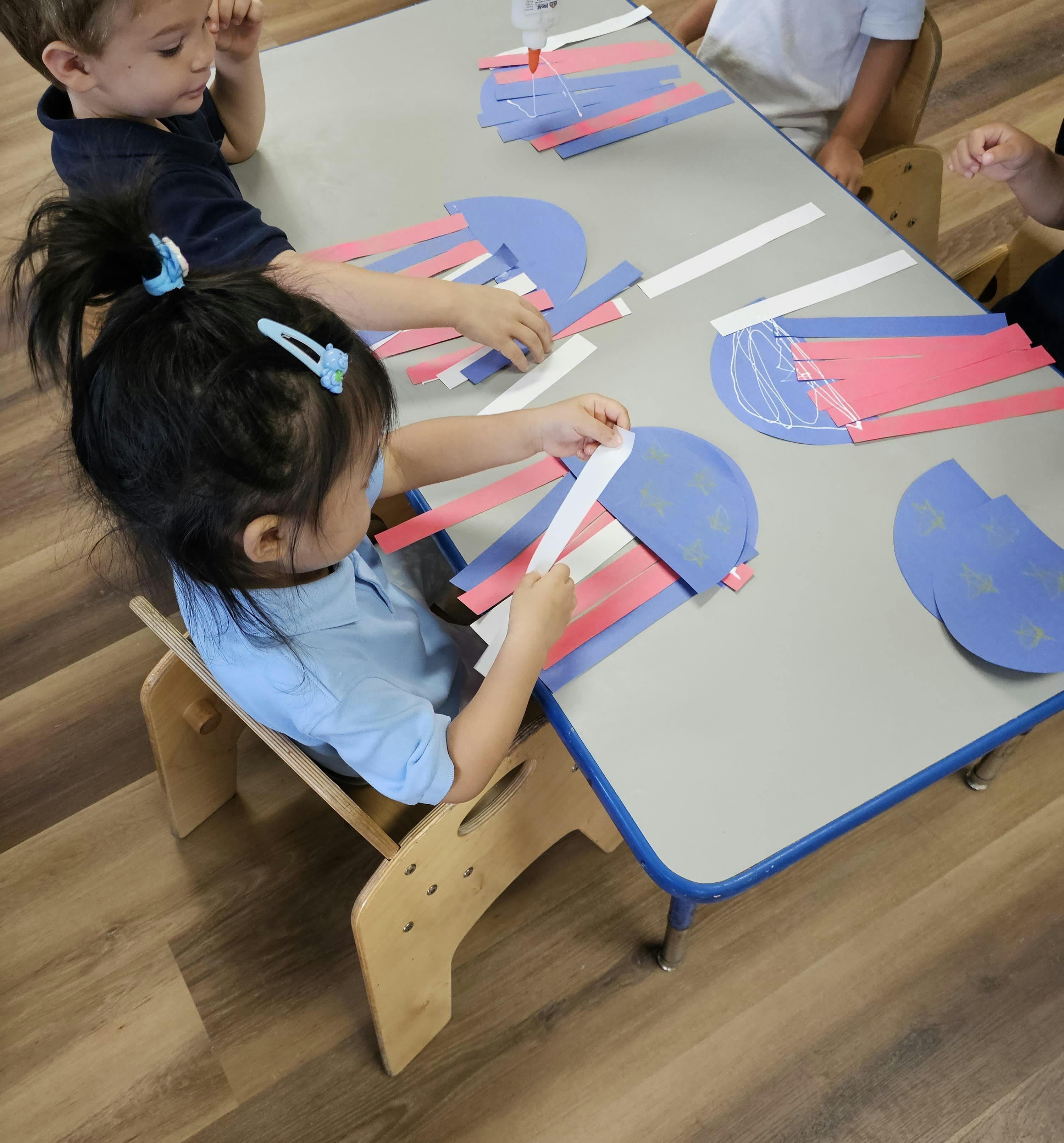 Children crafting jellyfish out of paper at a table