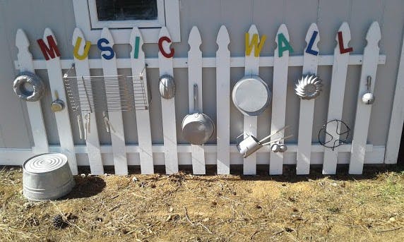 Picket fence with pots and pans hanging, text says "MUSIC WALL"