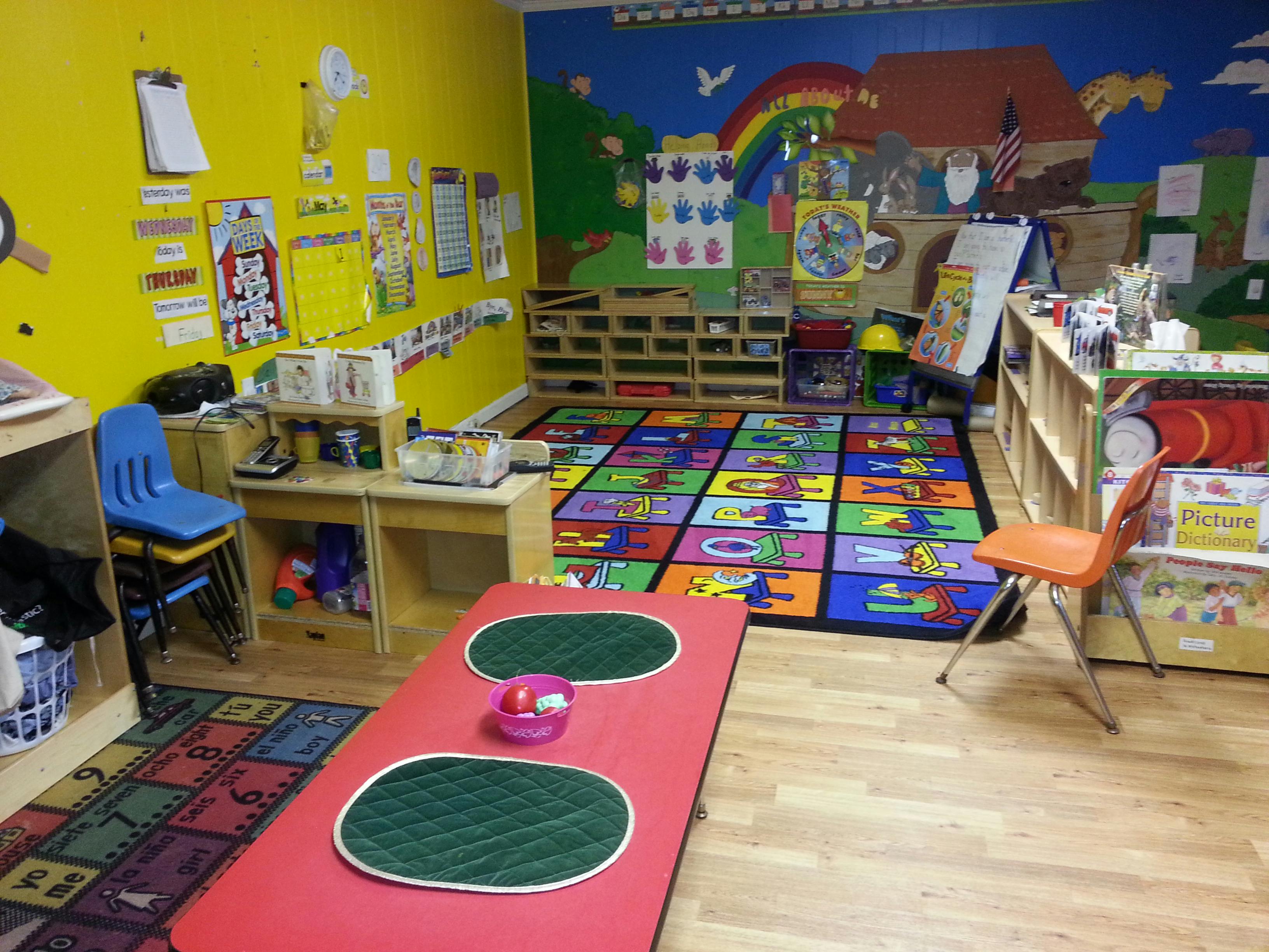 Colorful classroom with a large alphabet rug and various learning materials
