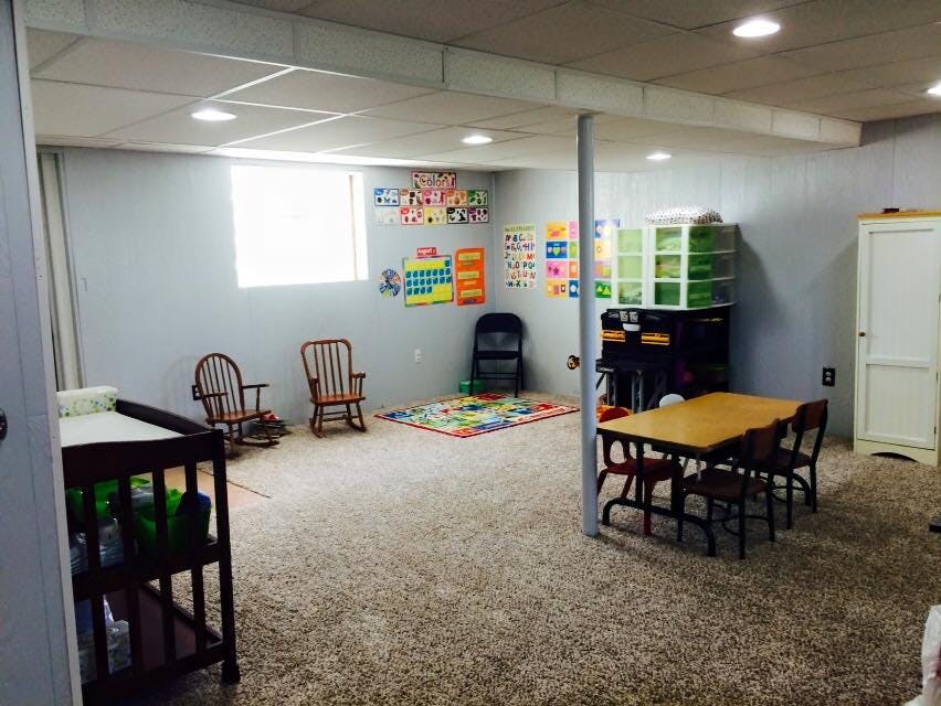 Playroom with small table and chairs, rocking chairs, and educational posters