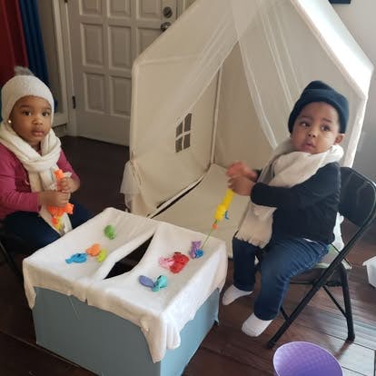 Two children playing with toys at a table