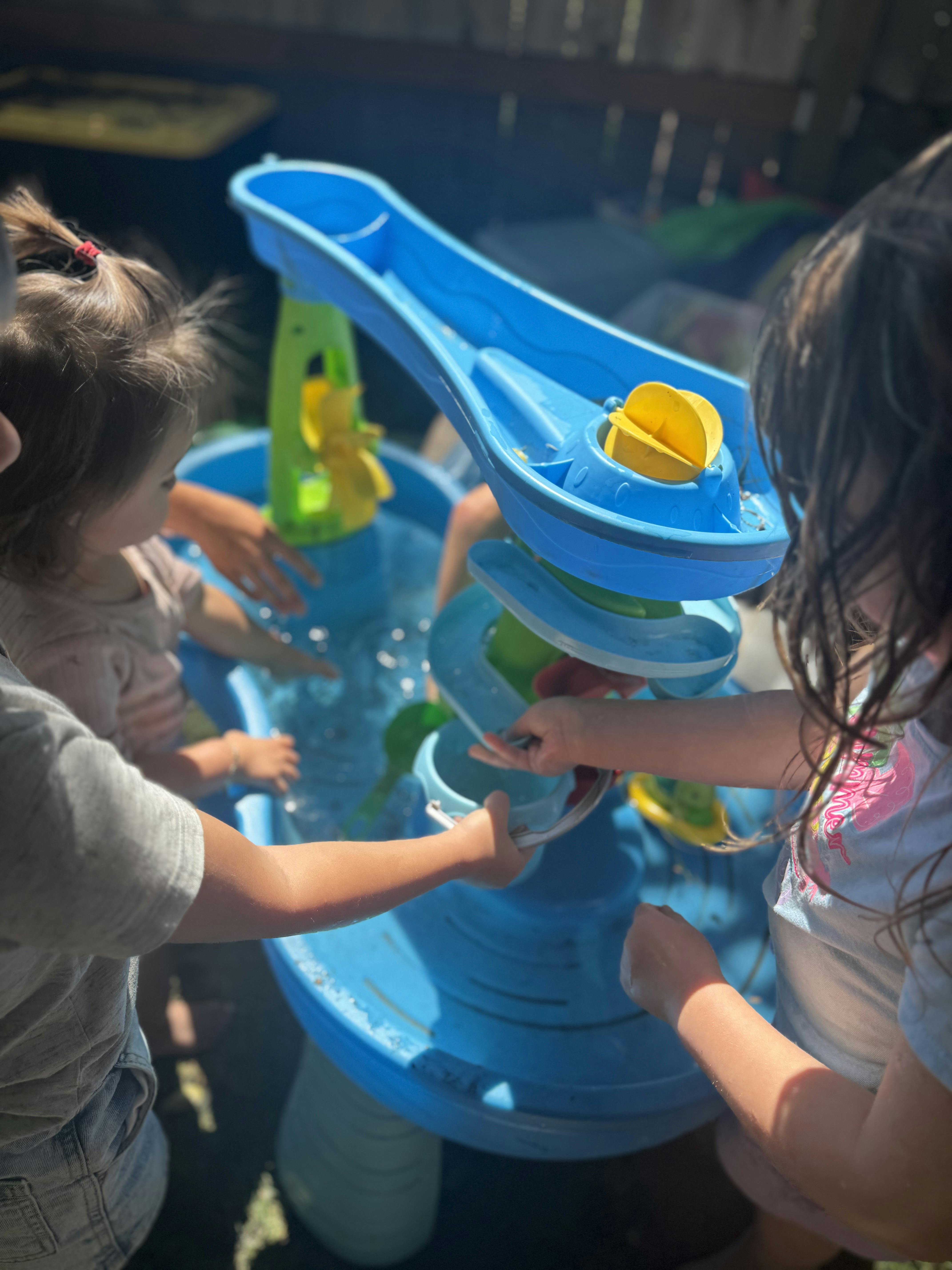 Children playing with a water table outdoors