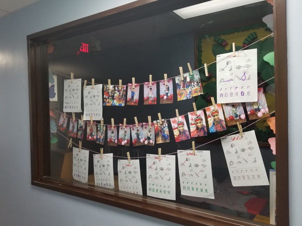 Photos and papers hanging on strings with clothespins in a window display case