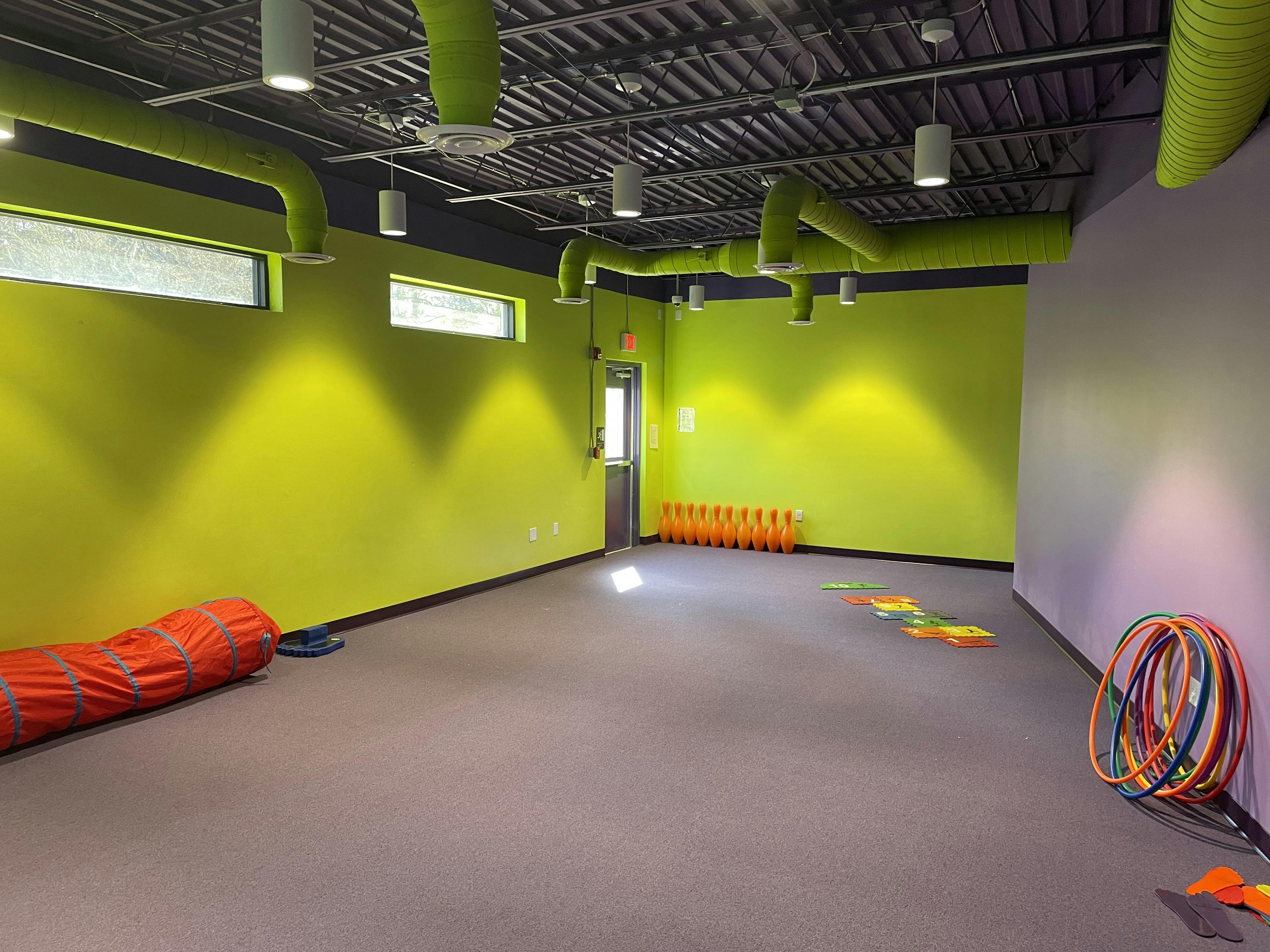 Empty activity room with green and purple walls and play equipment