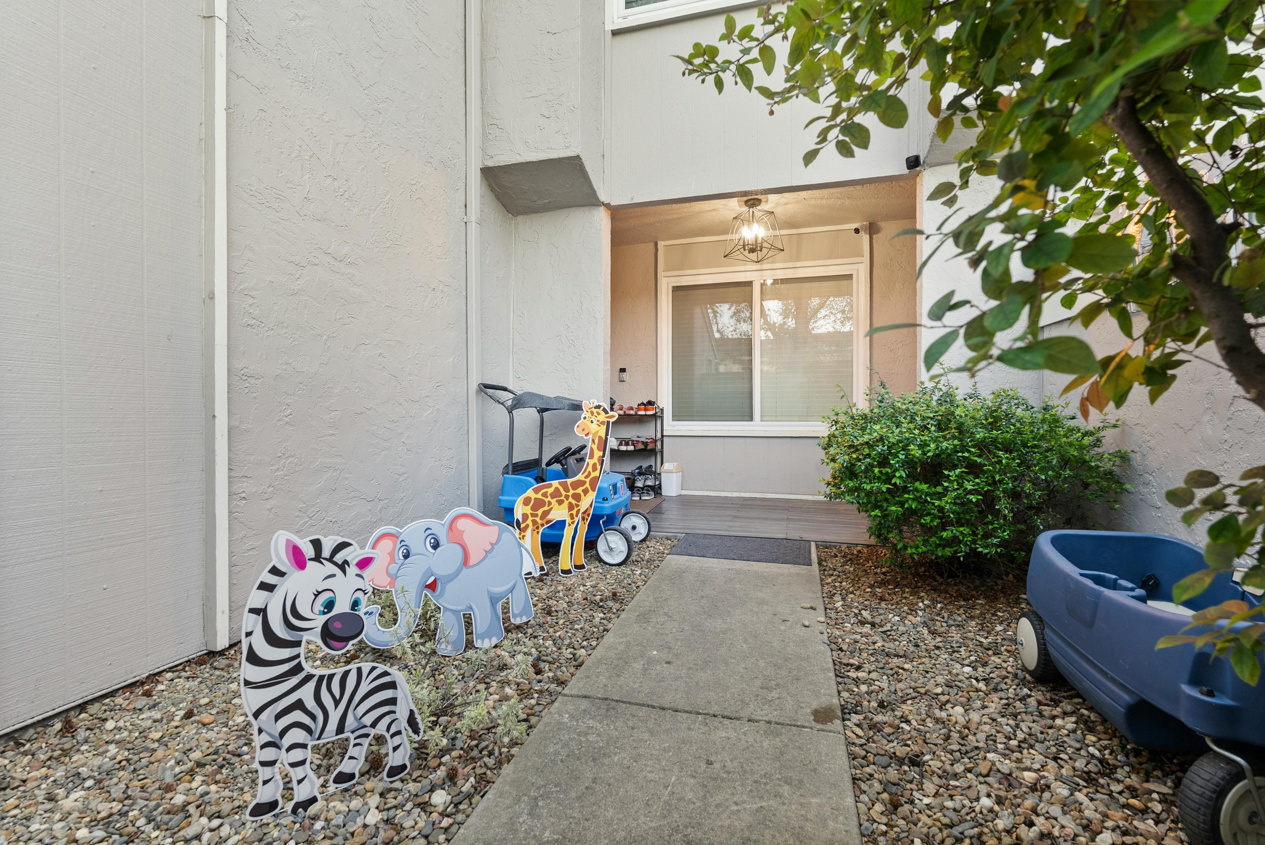 Decorative yard cutouts of a zebra, elephant, and giraffe next to a front door