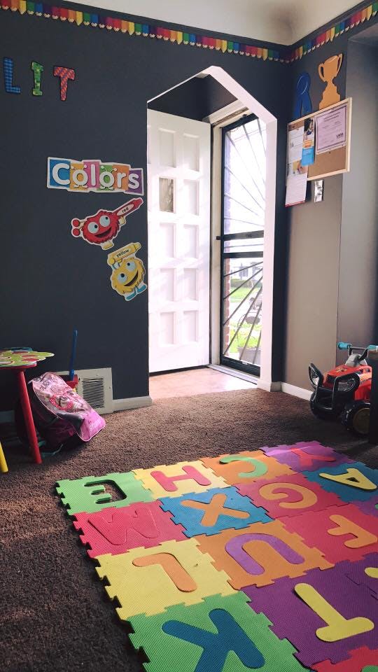 Playroom with alphabet mat on carpet, open door, and wall decorations