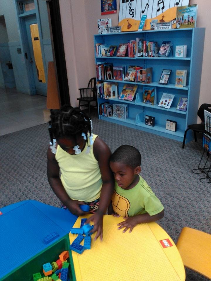 Two children playing with building blocks at a table