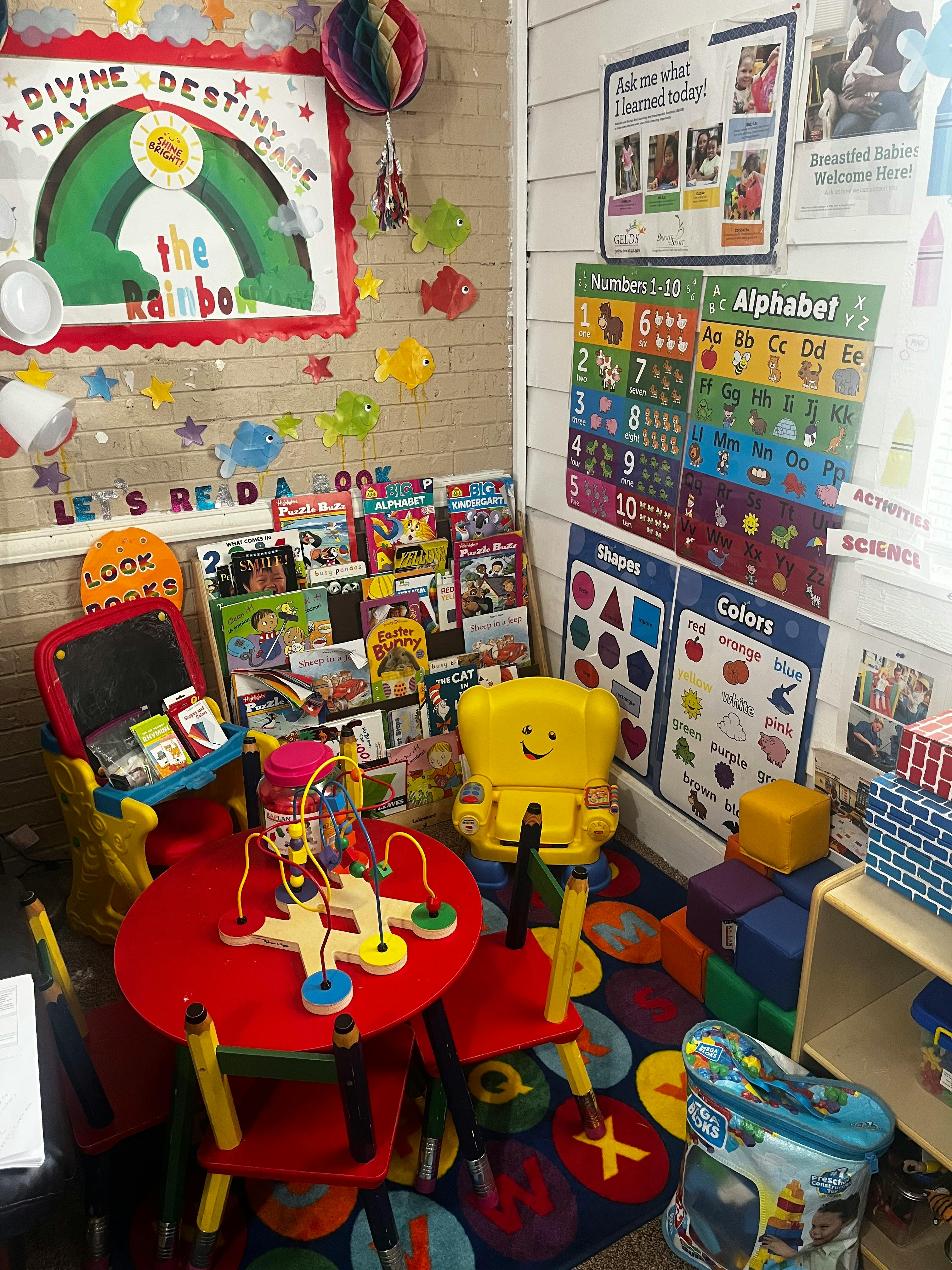 Classroom with a small red table and chairs, book display, and educational posters