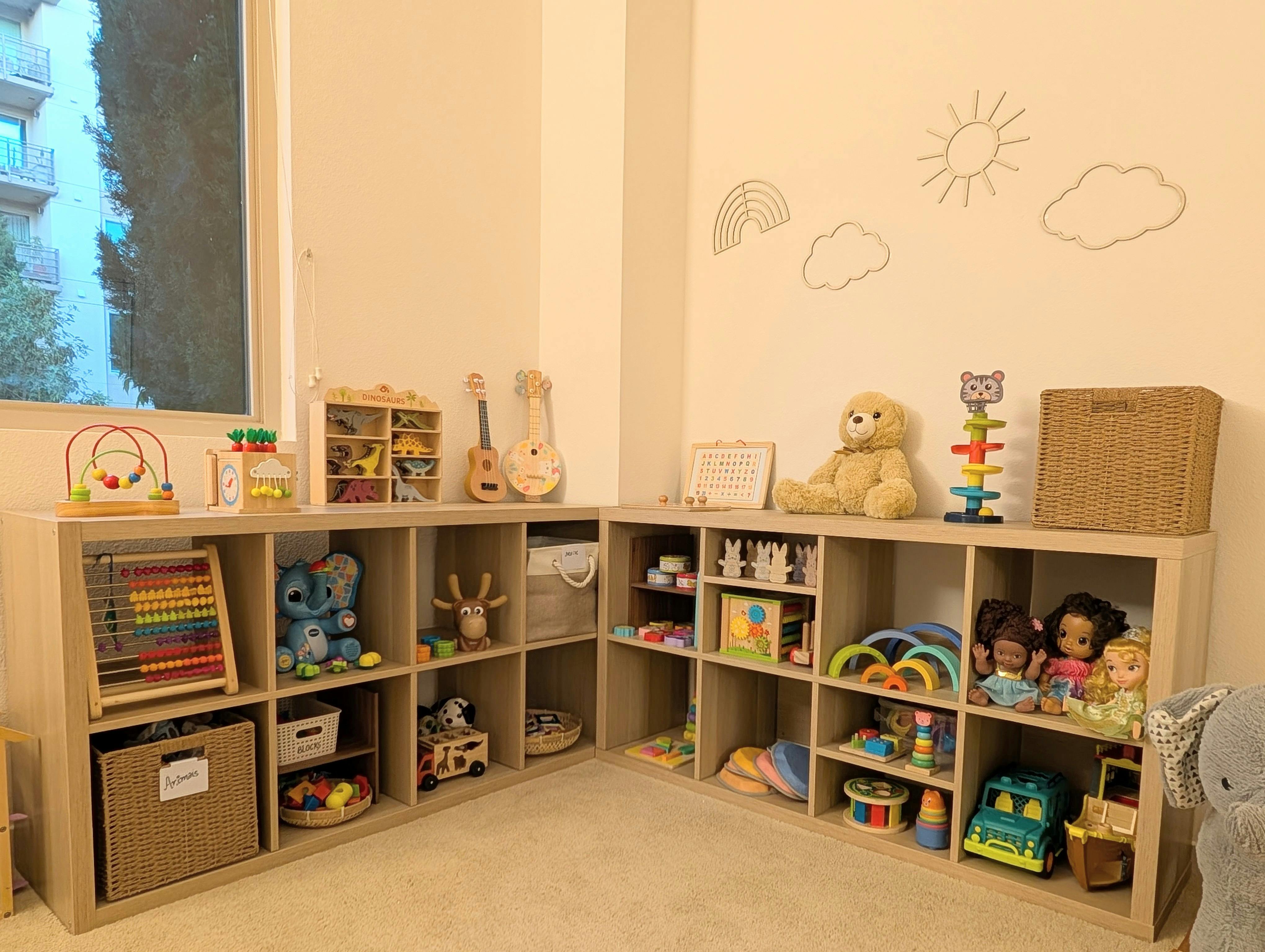 Corner of a room with wooden cube shelves filled with toys