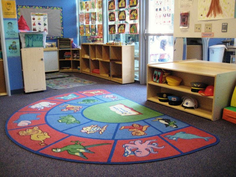 Colorful semicircular rug with animal illustrations in a classroom