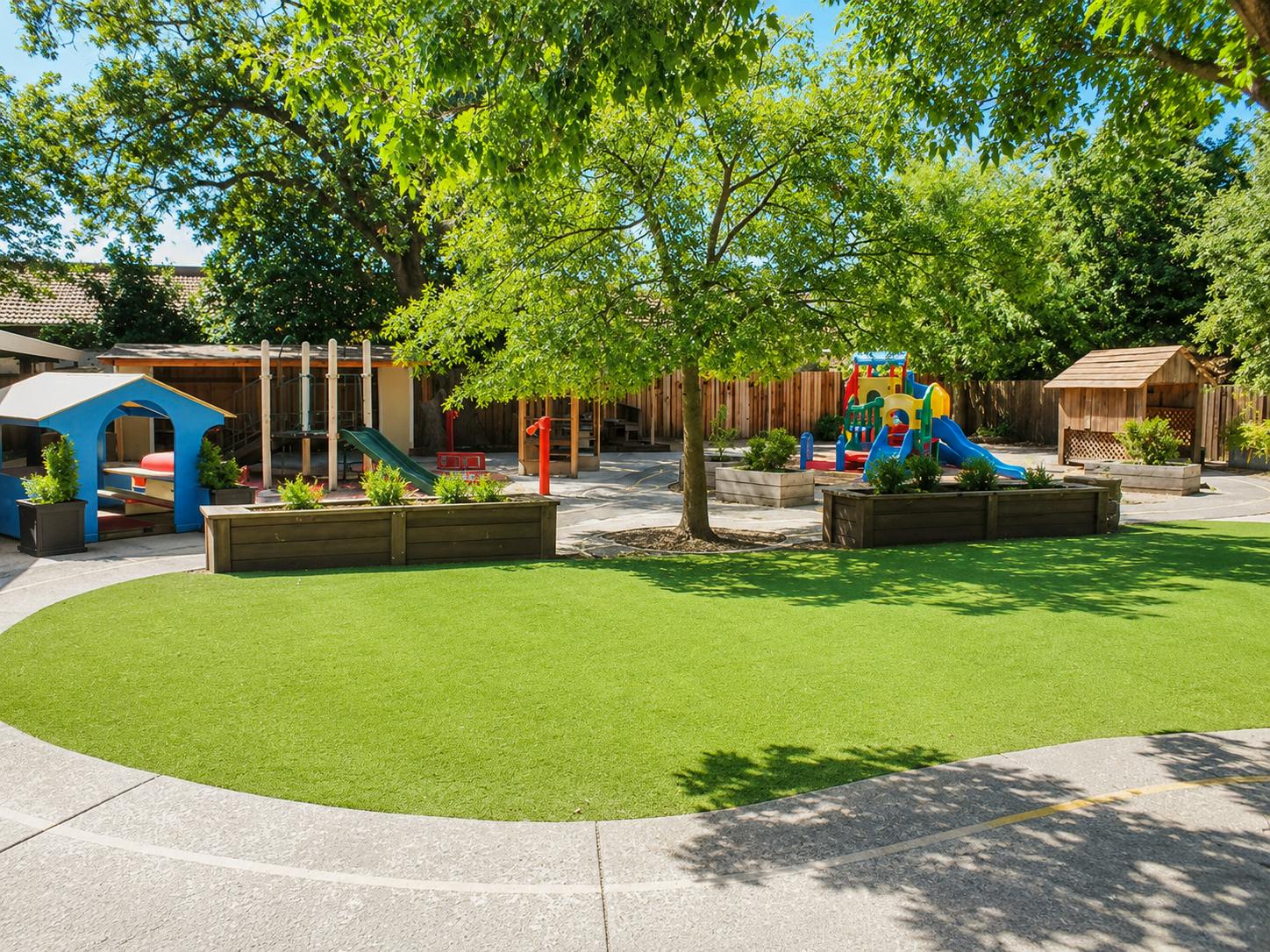 Outdoor playground with artificial grass and play structures