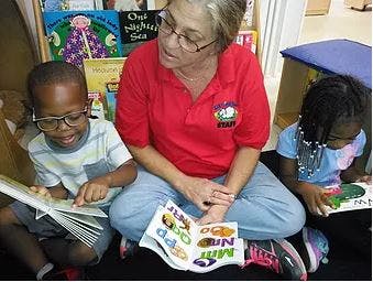 Adult reading to two children