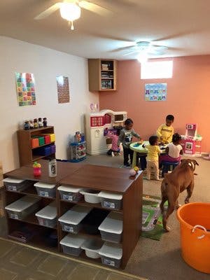Children playing in a room with a dog