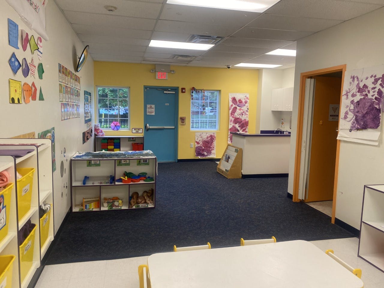 Empty classroom with colorful walls and child-sized furniture