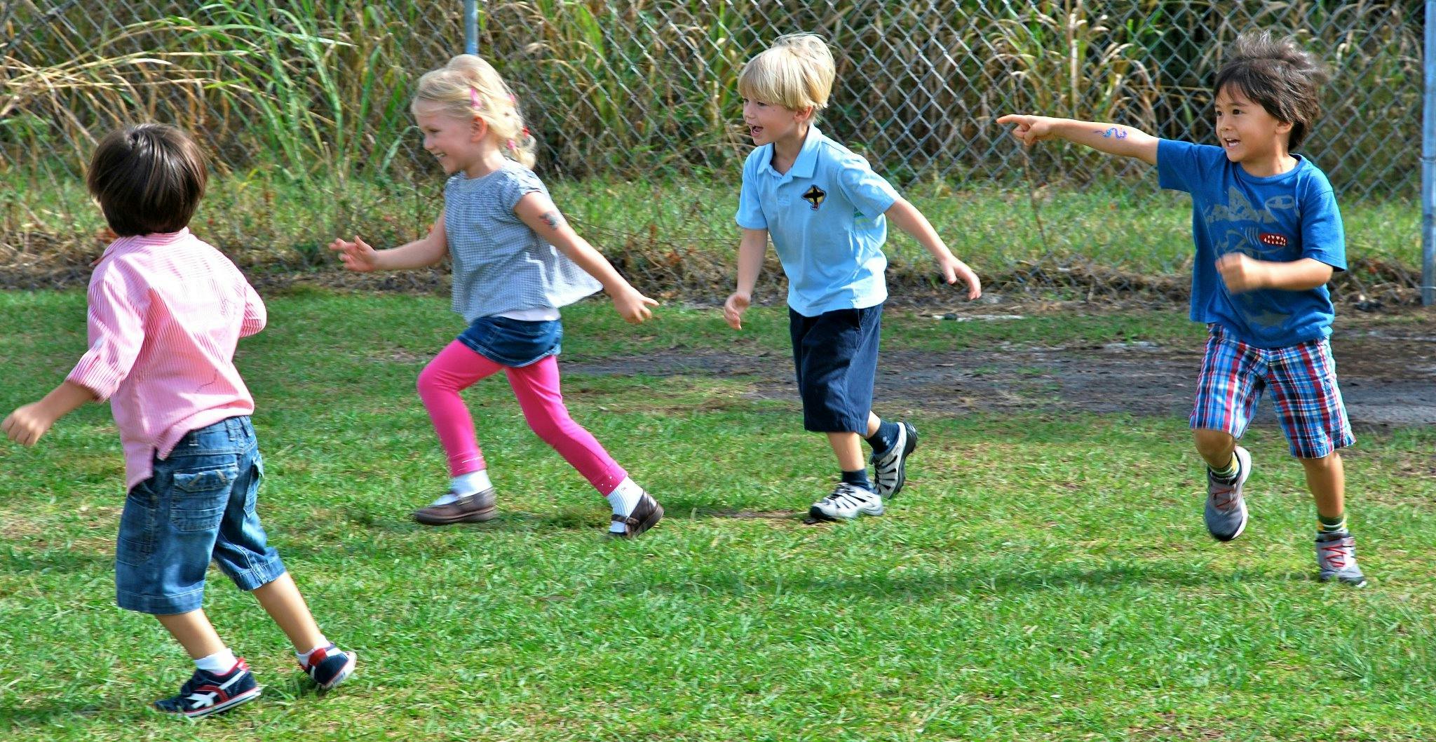 Four children running on grass