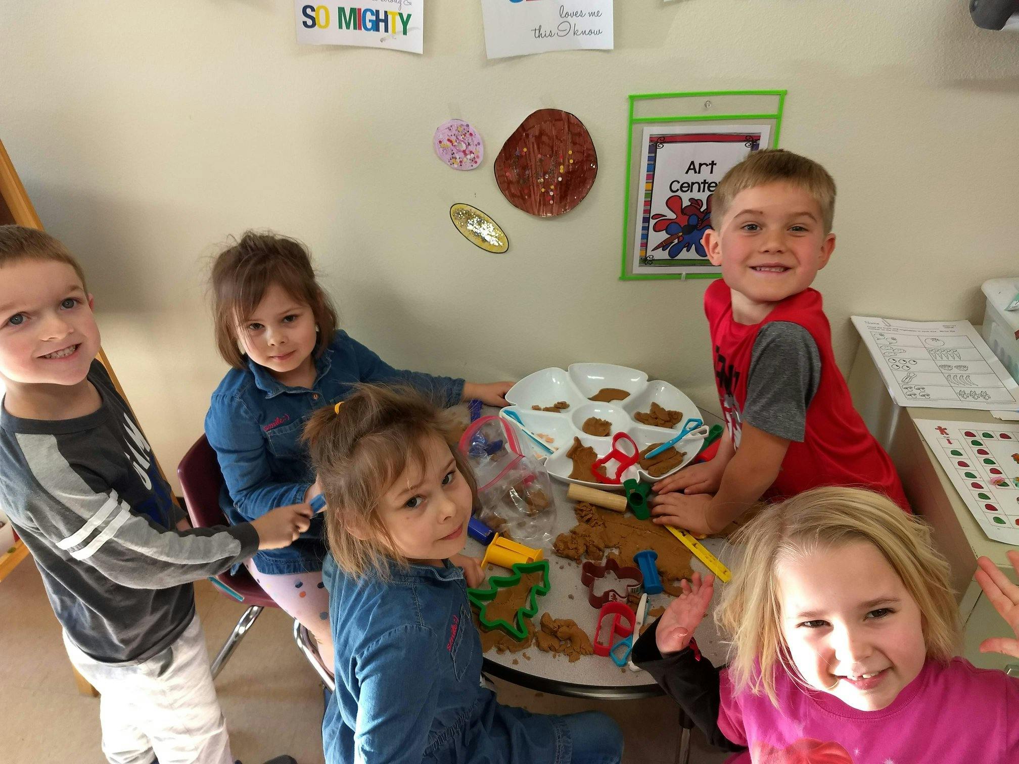 Four children and one teen around a table with crafts
