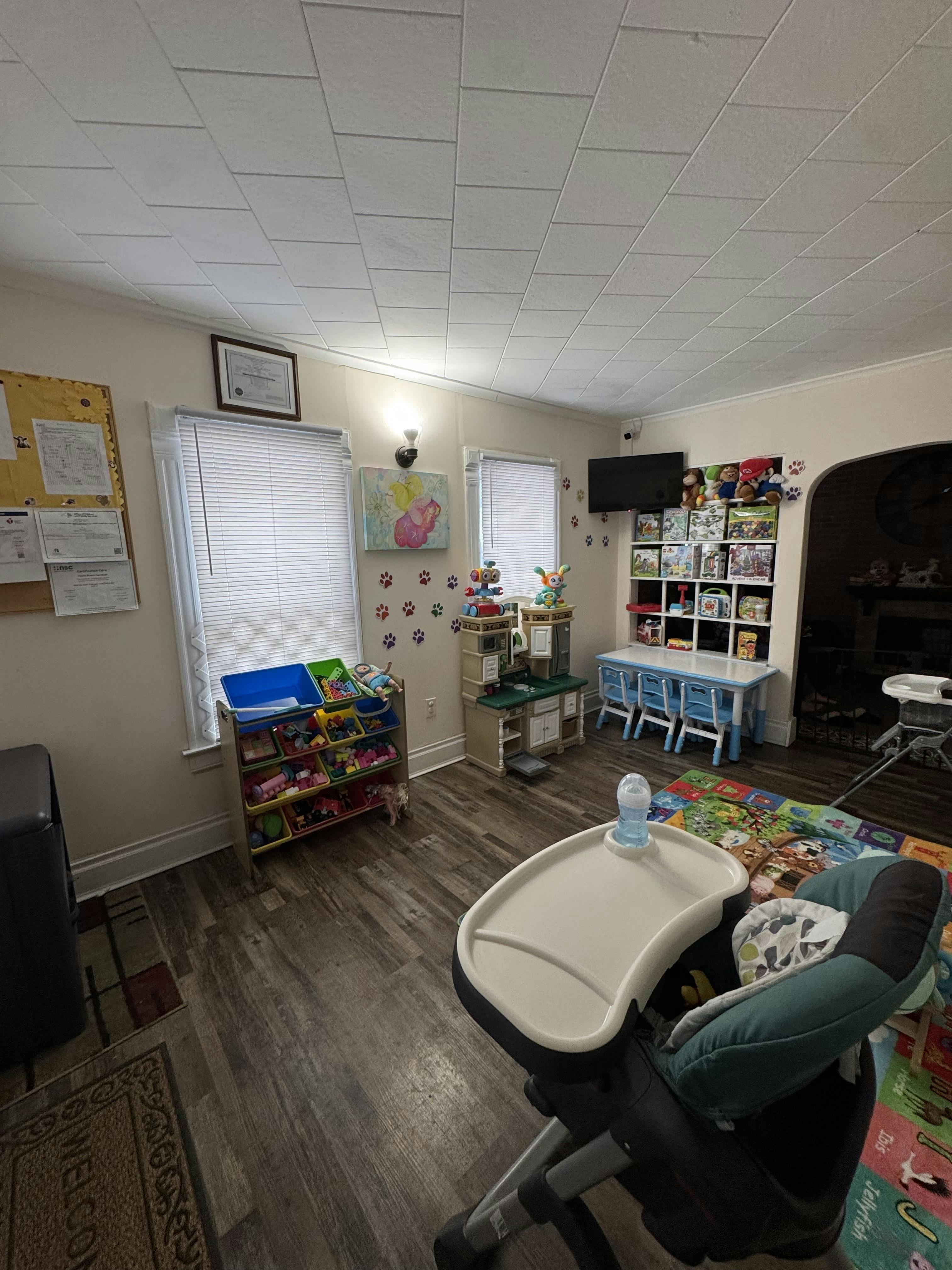 High chair in a room with children's toys and a small table with chairs