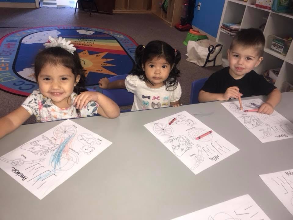 Three children coloring at a table