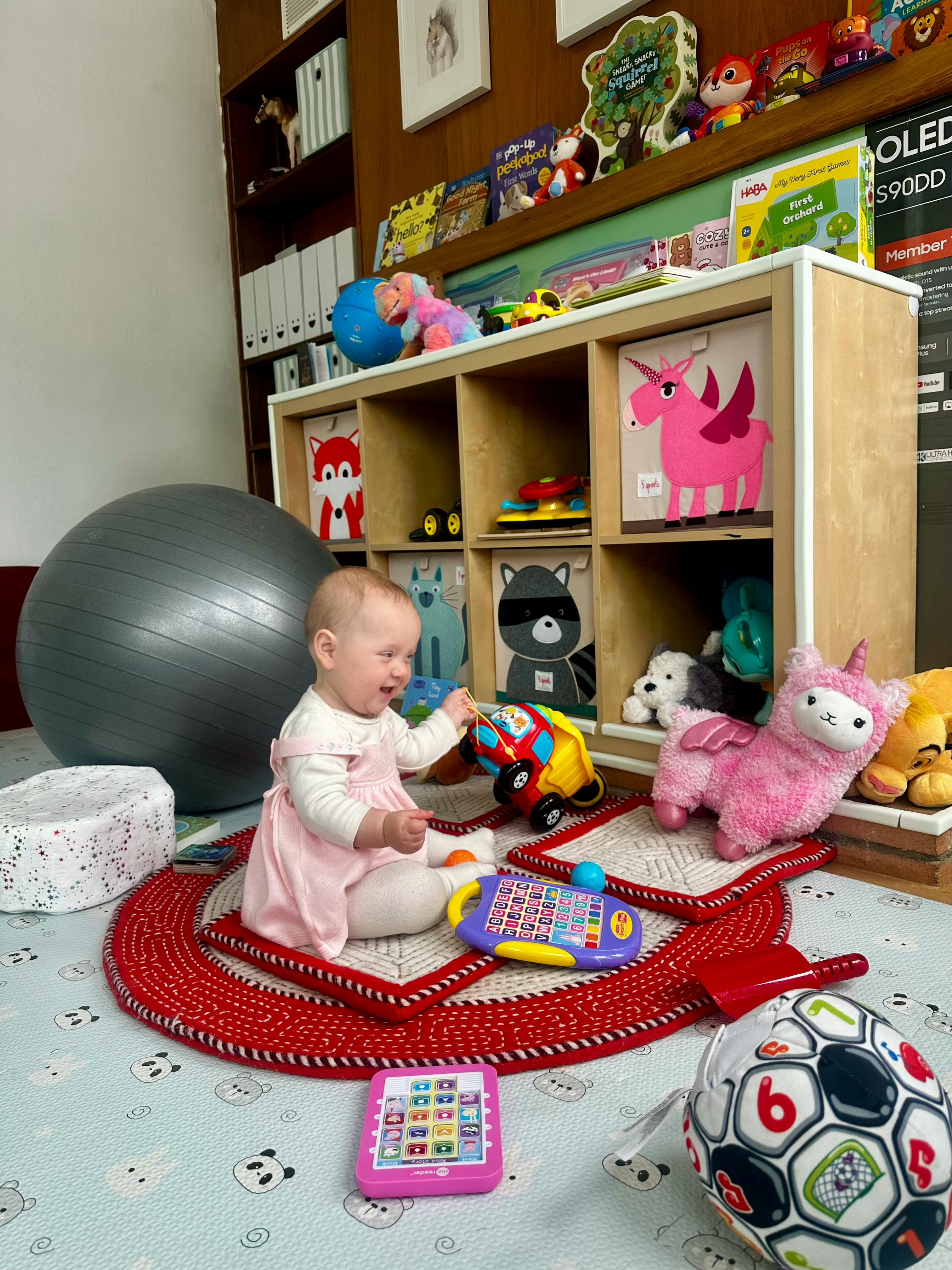 Child playing with toys on a mat in a playroom