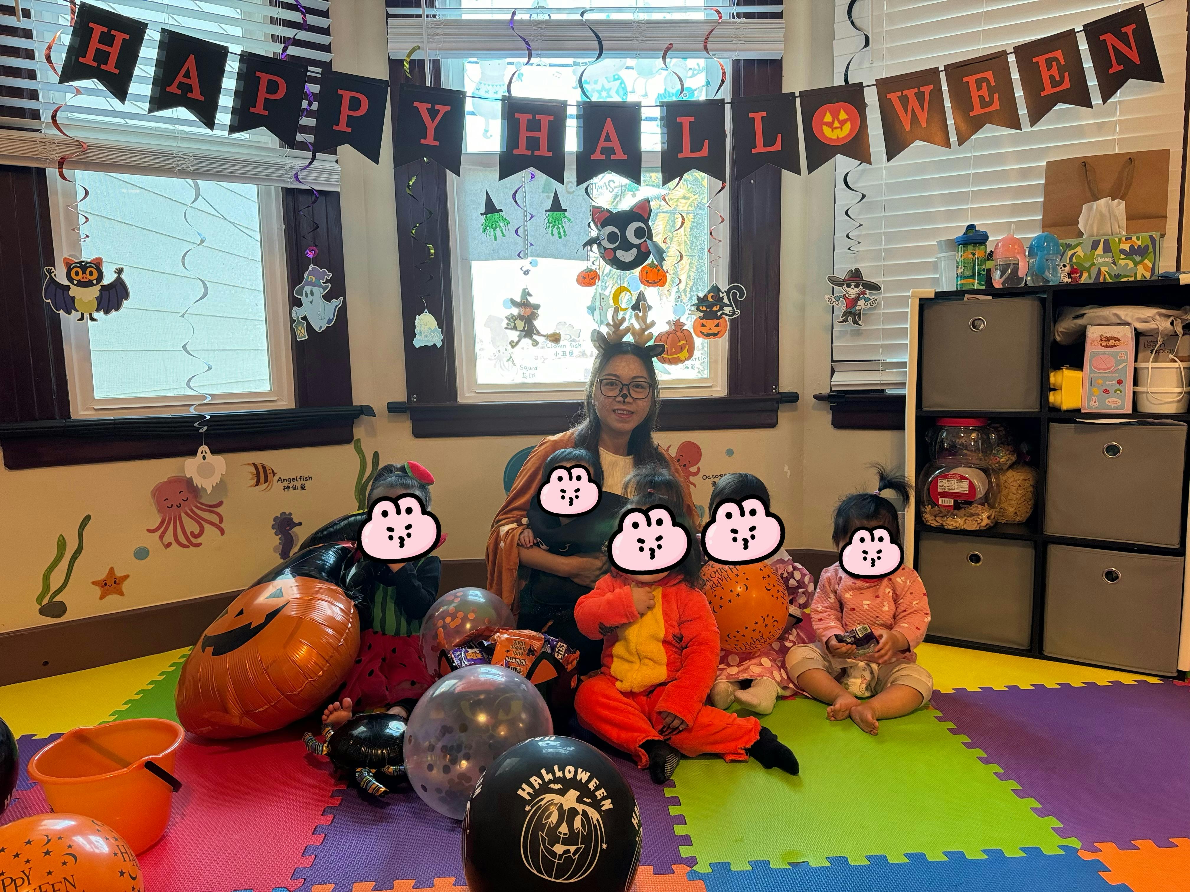 Adult and children in a room decorated for Halloween