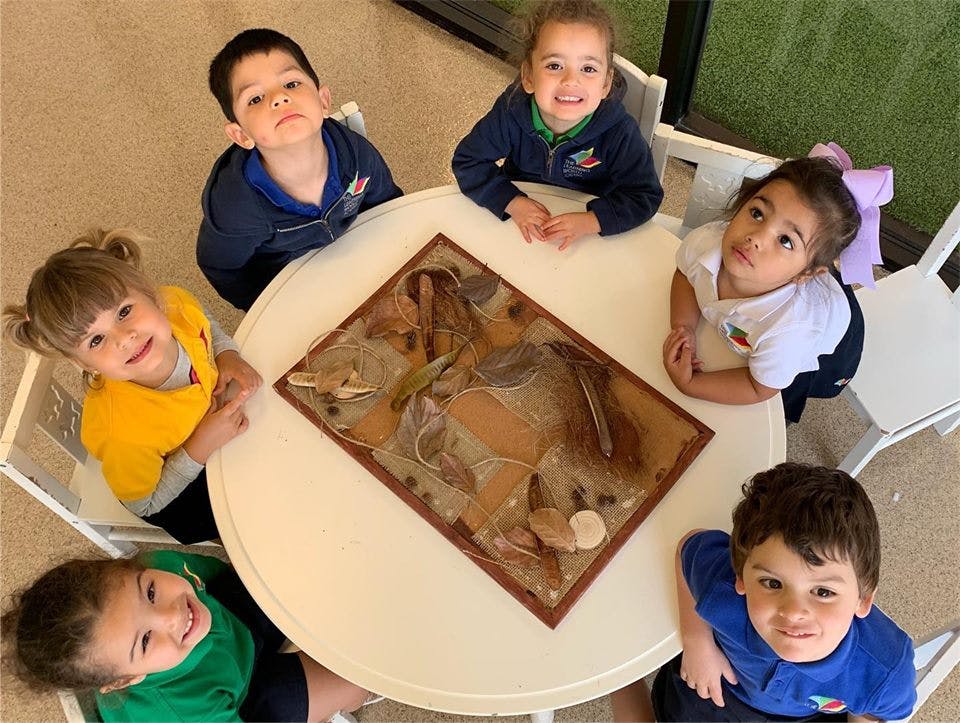 Five children sitting around a table with a game