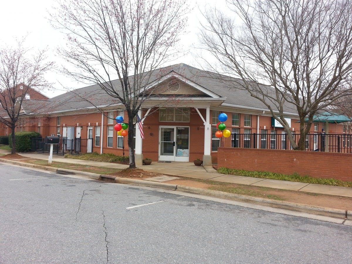 Brick building with a covered entrance and colorful balloons