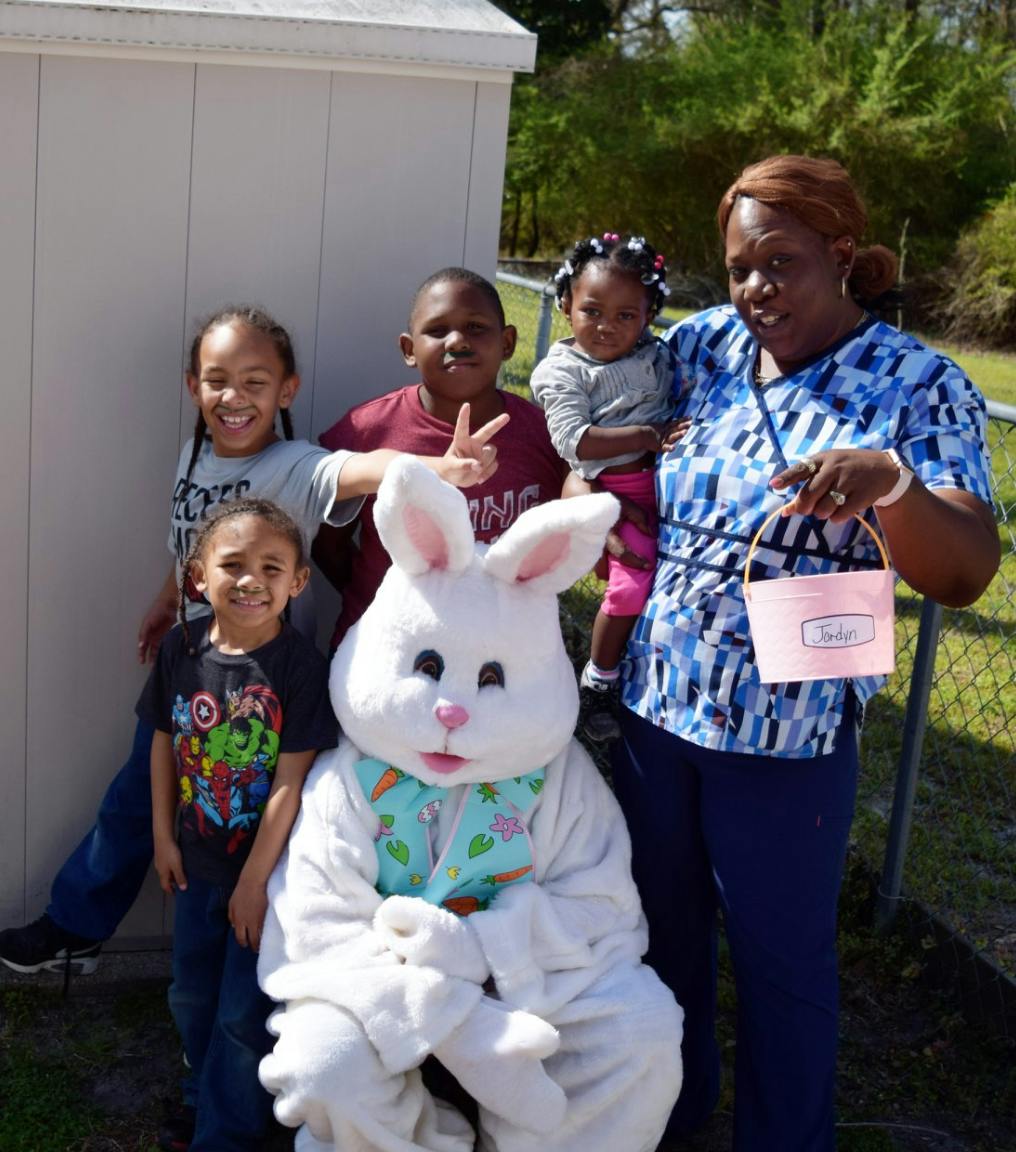 Person in bunny costume with an adult and multiple children