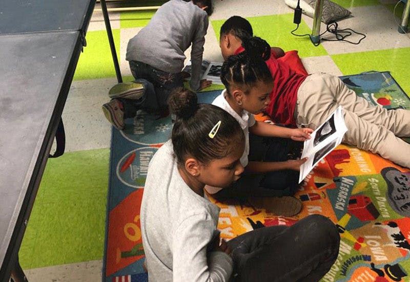 Children reading books on a colorful rug