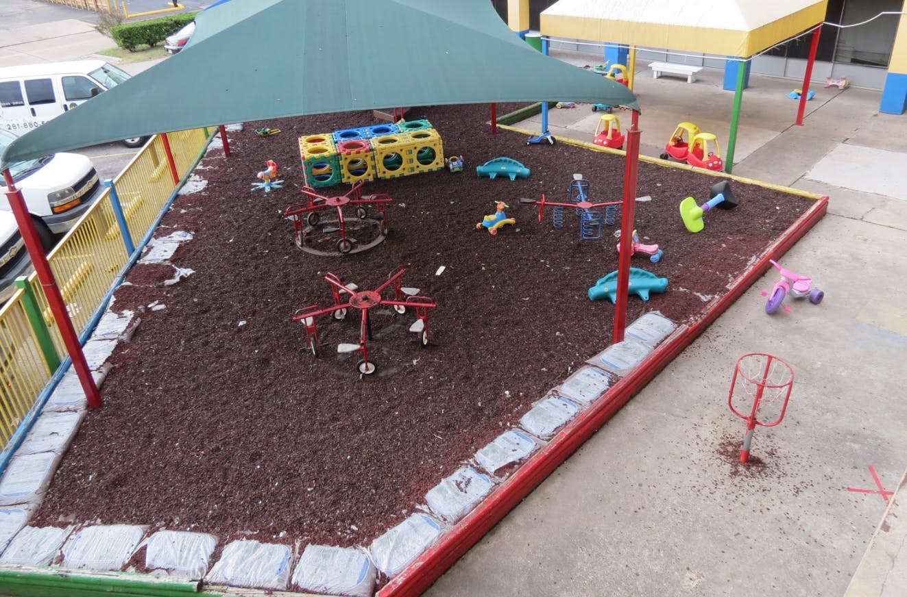 Playground with wood chips, shade cover, and various play equipment