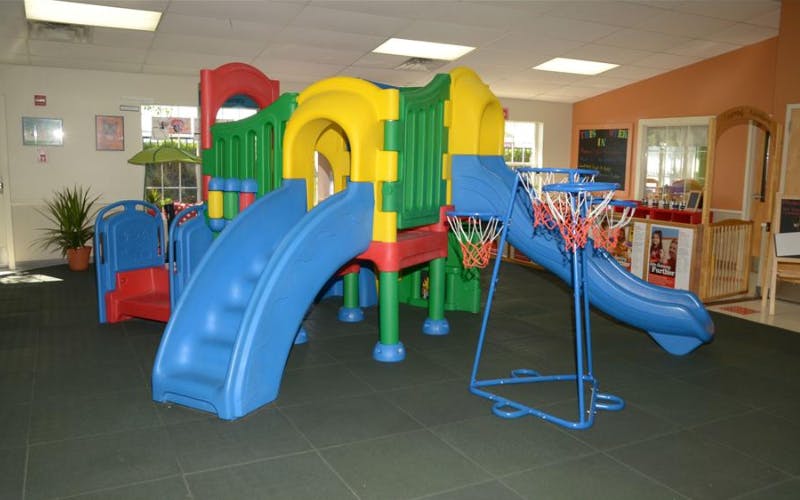 Colorful indoor playground with slides and basketball hoops