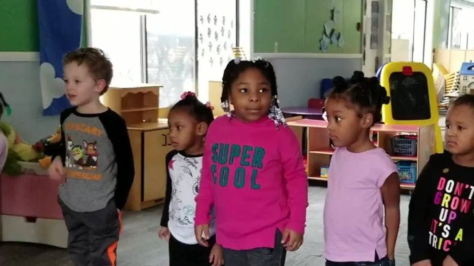 Five children standing in a room