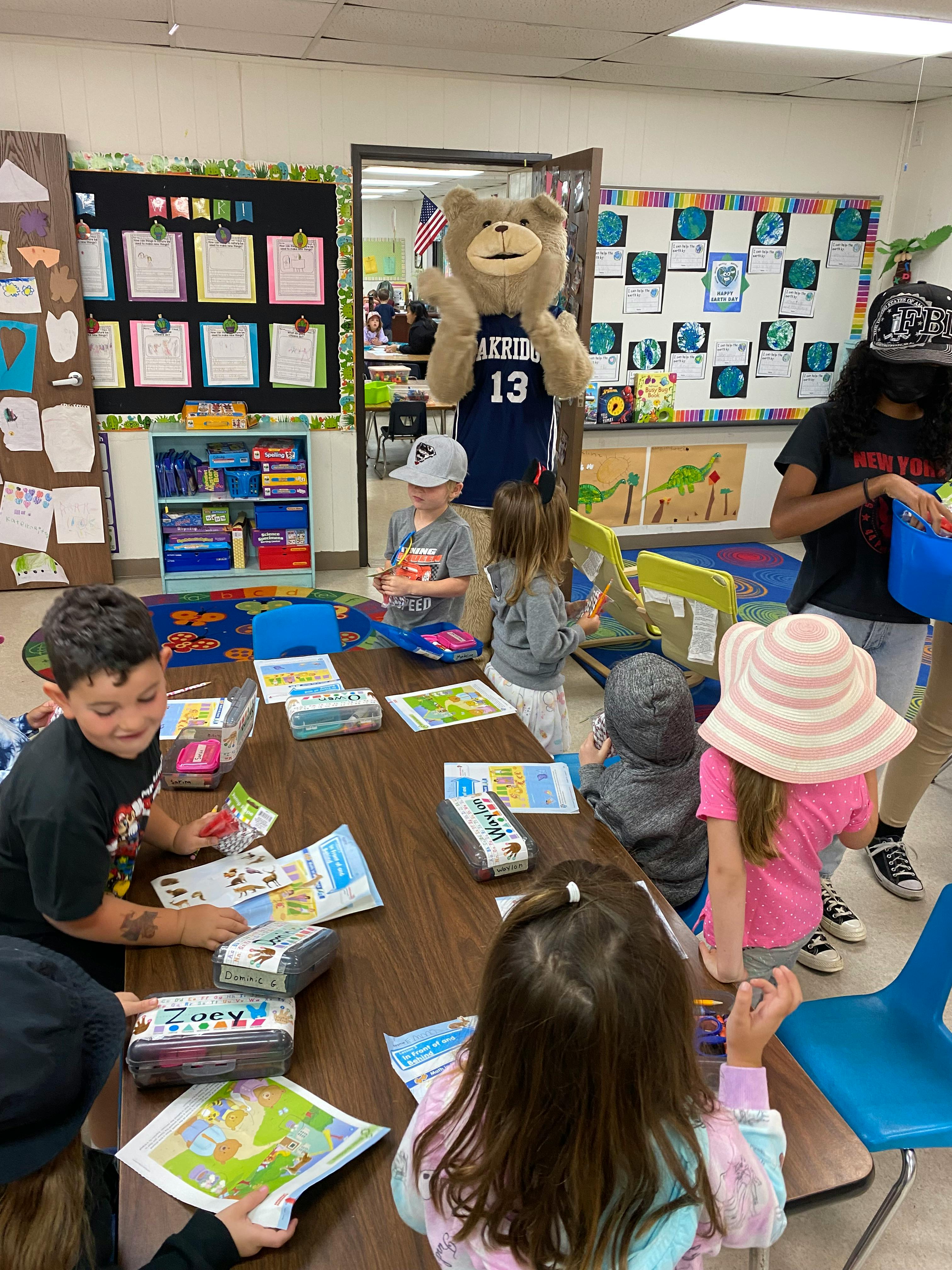 Mascot in a bear costume with children in a classroom