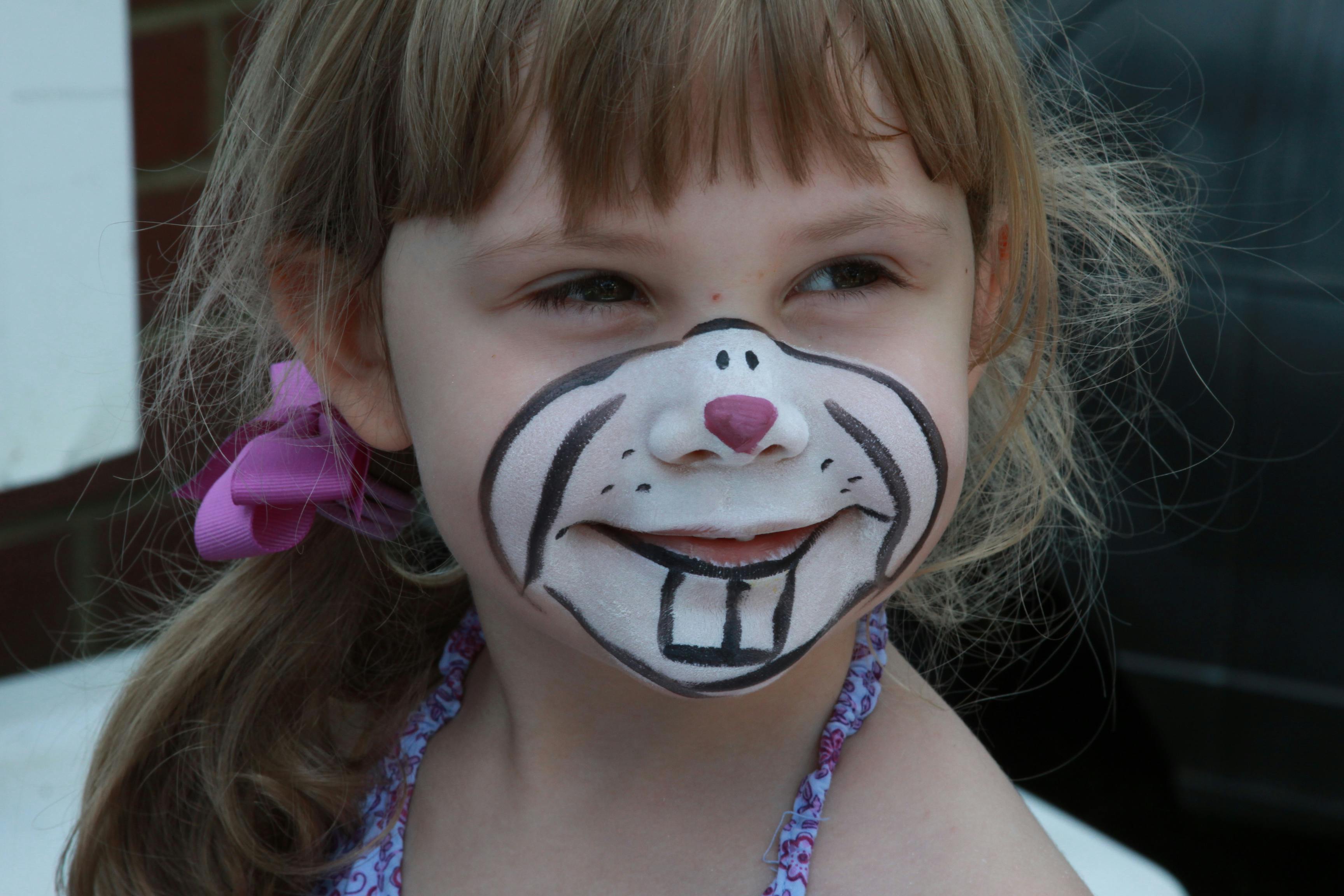 Child with face painted like a bunny