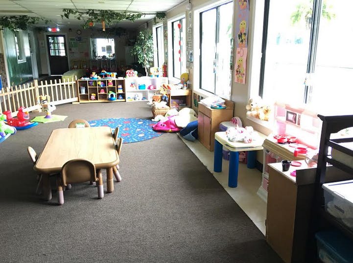 Playroom with small tables and chairs, toys, and large windows