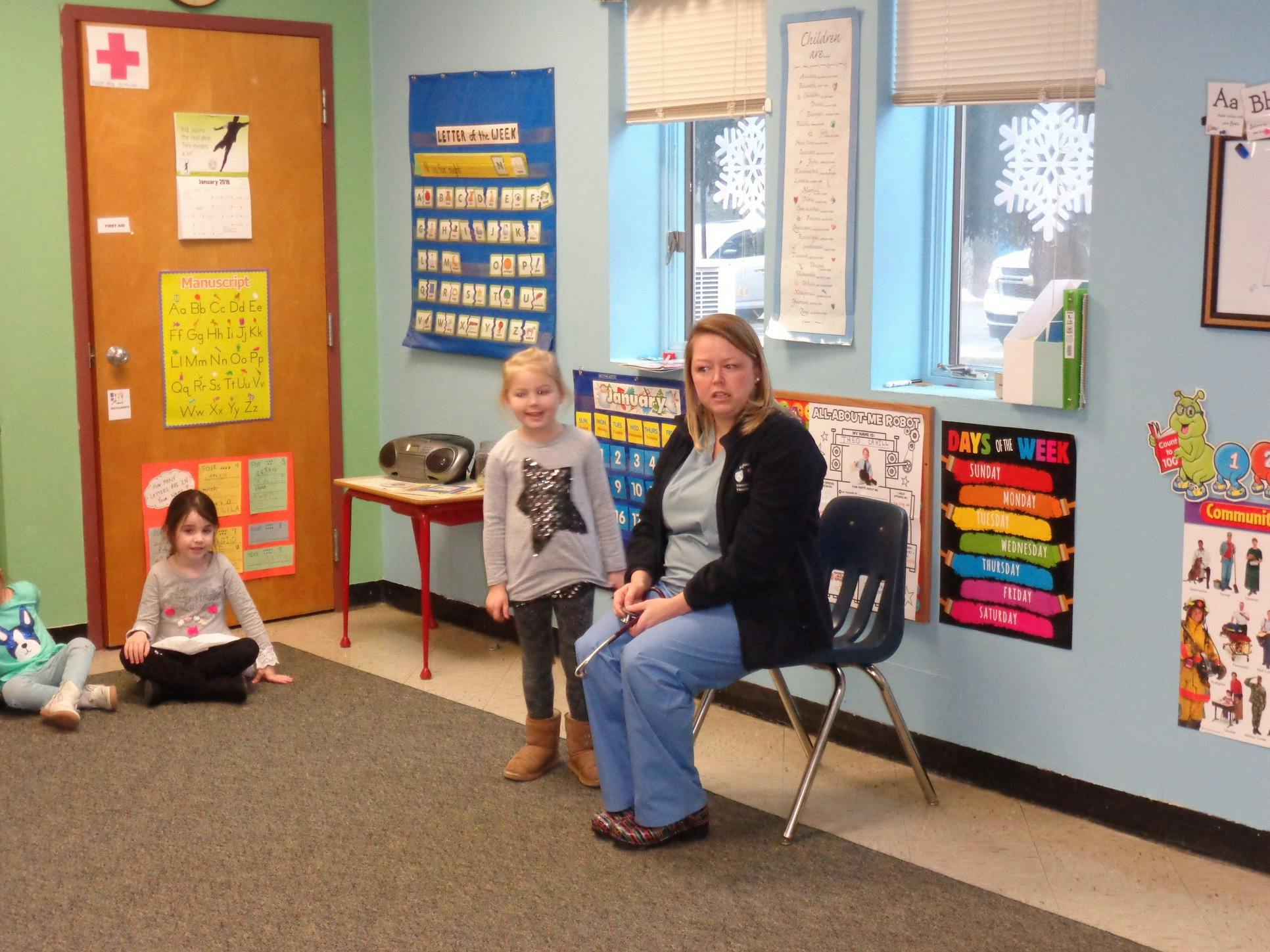 Adult and two children in a classroom