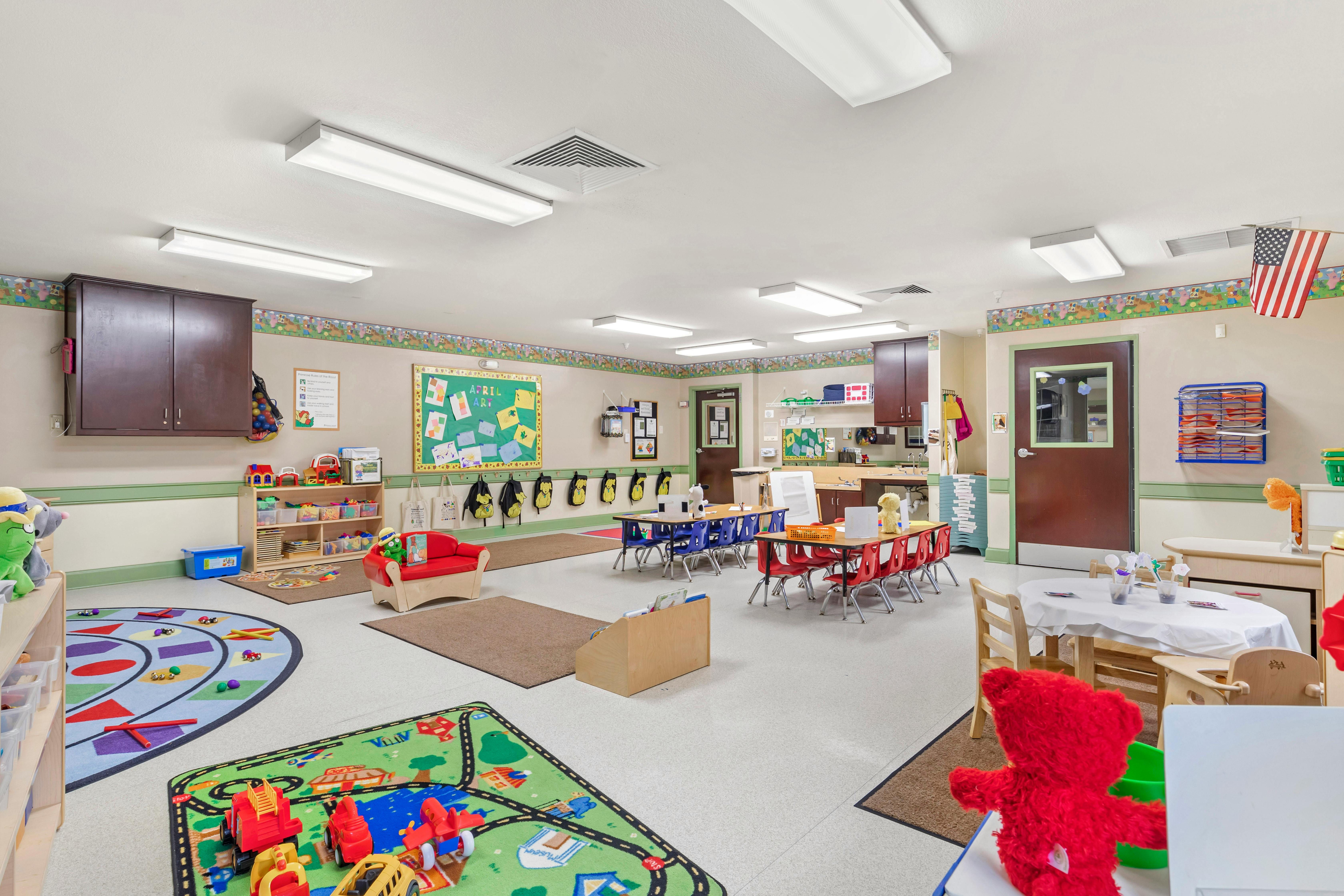 A colorful classroom with small tables and chairs for children