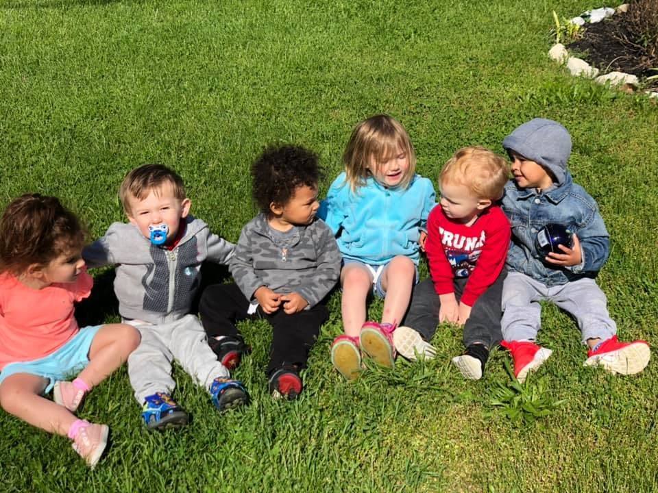 Six children sitting on grass