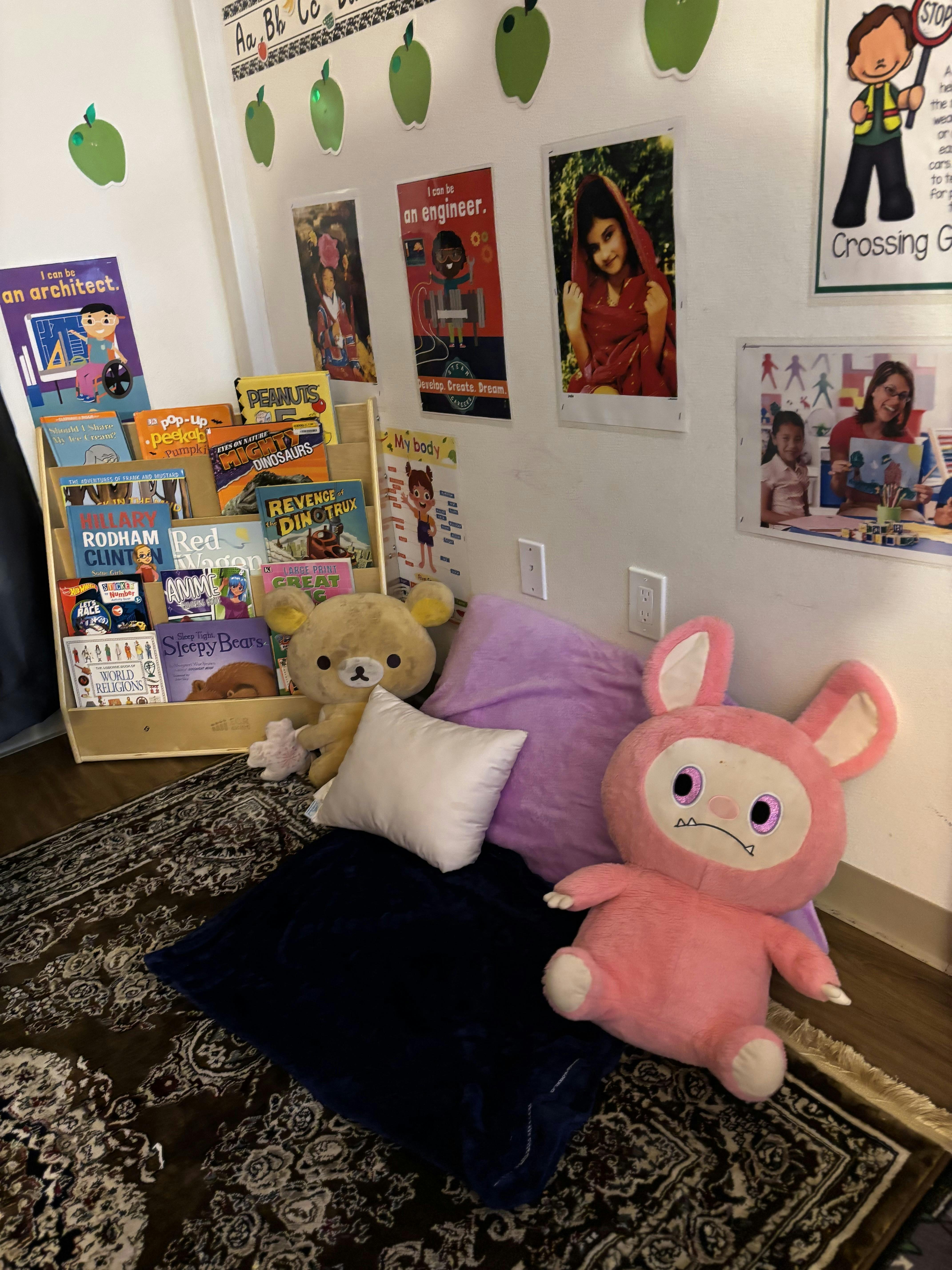 Bookcase with books, stuffed animals, and pillows on a rug