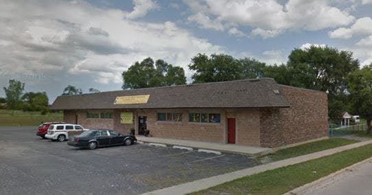 Brick building with a parking lot and cars in front