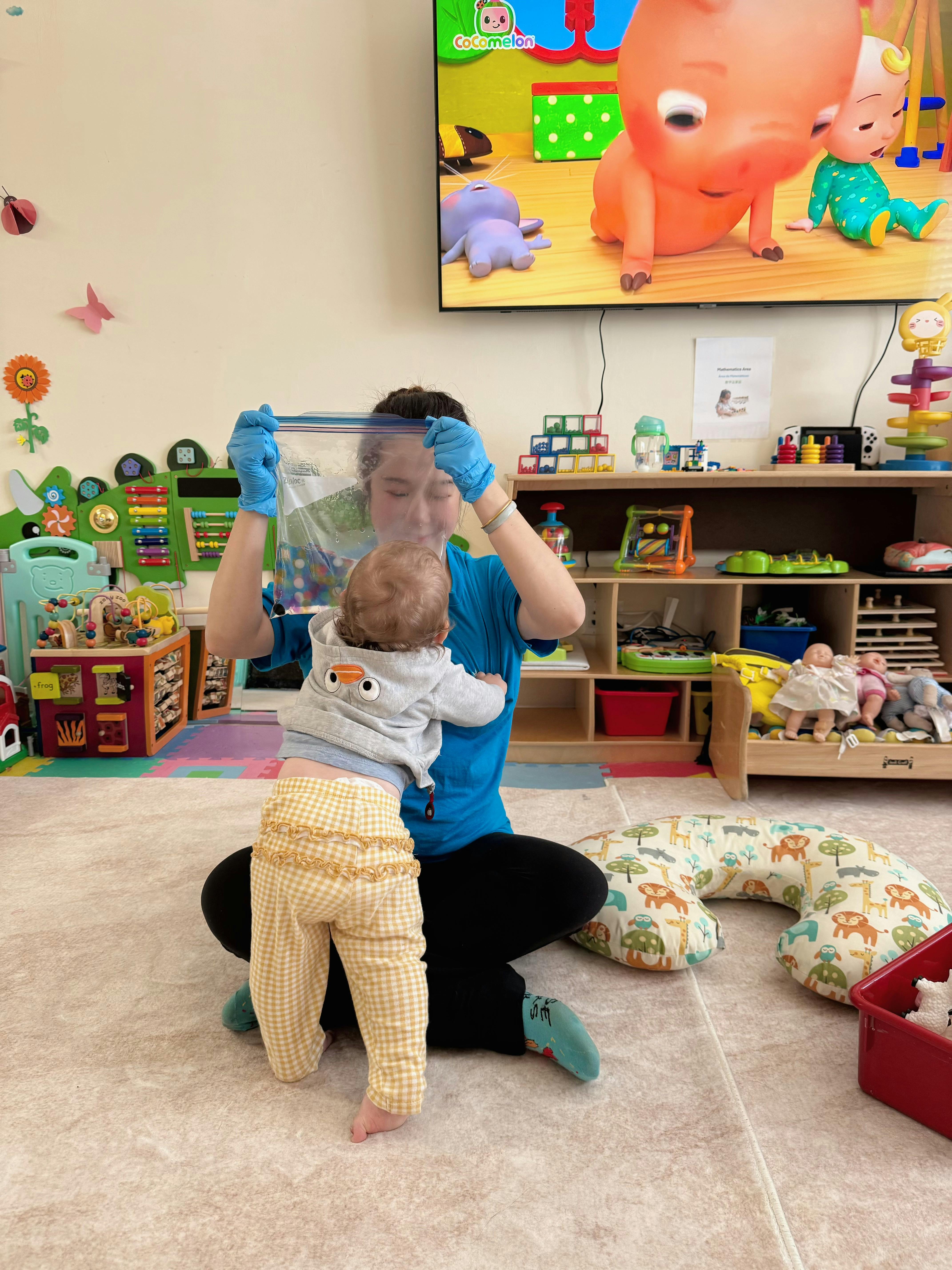 Person holding a plastic bag of sensory items for a child in a classroom