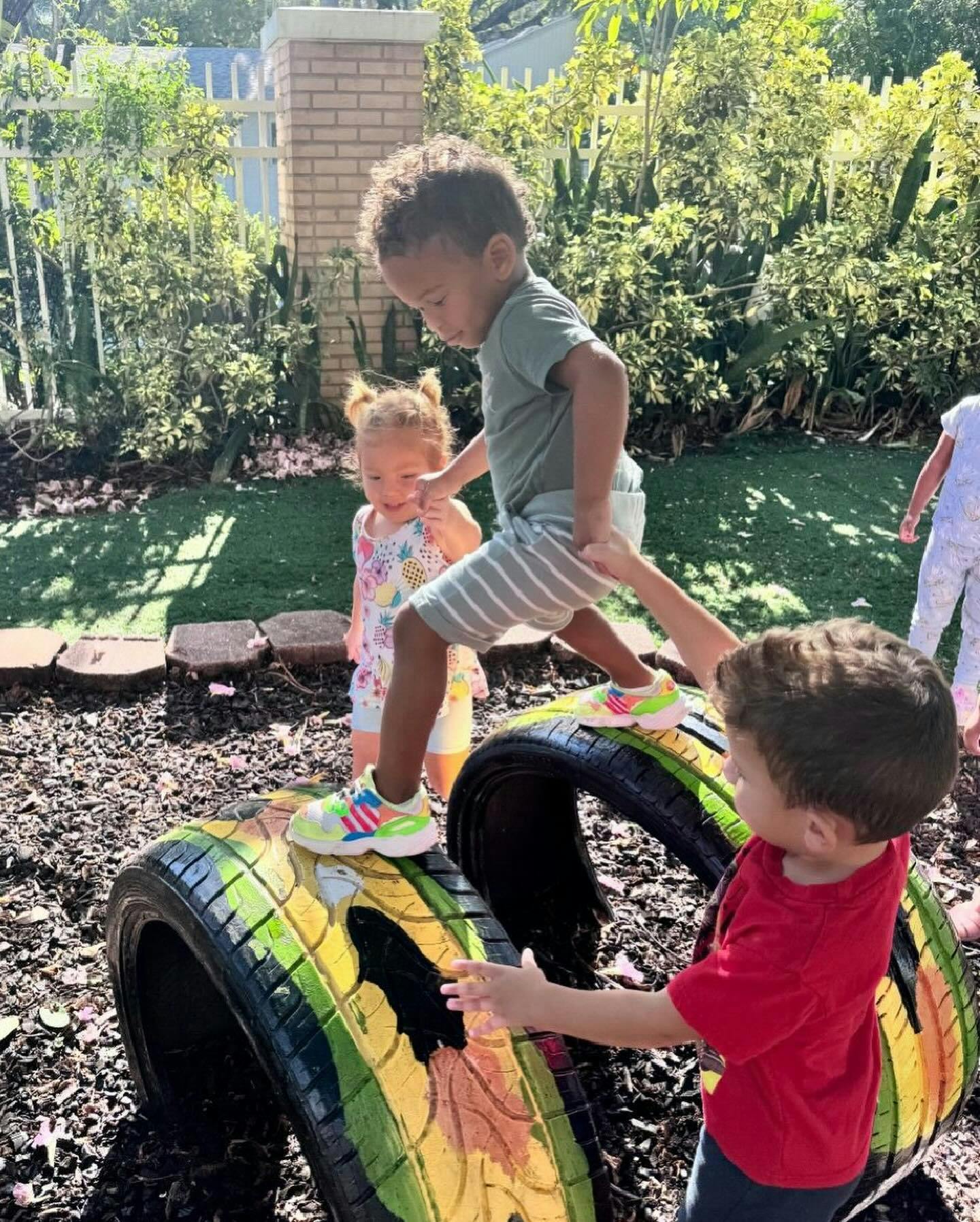 Children playing on painted tires outdoors