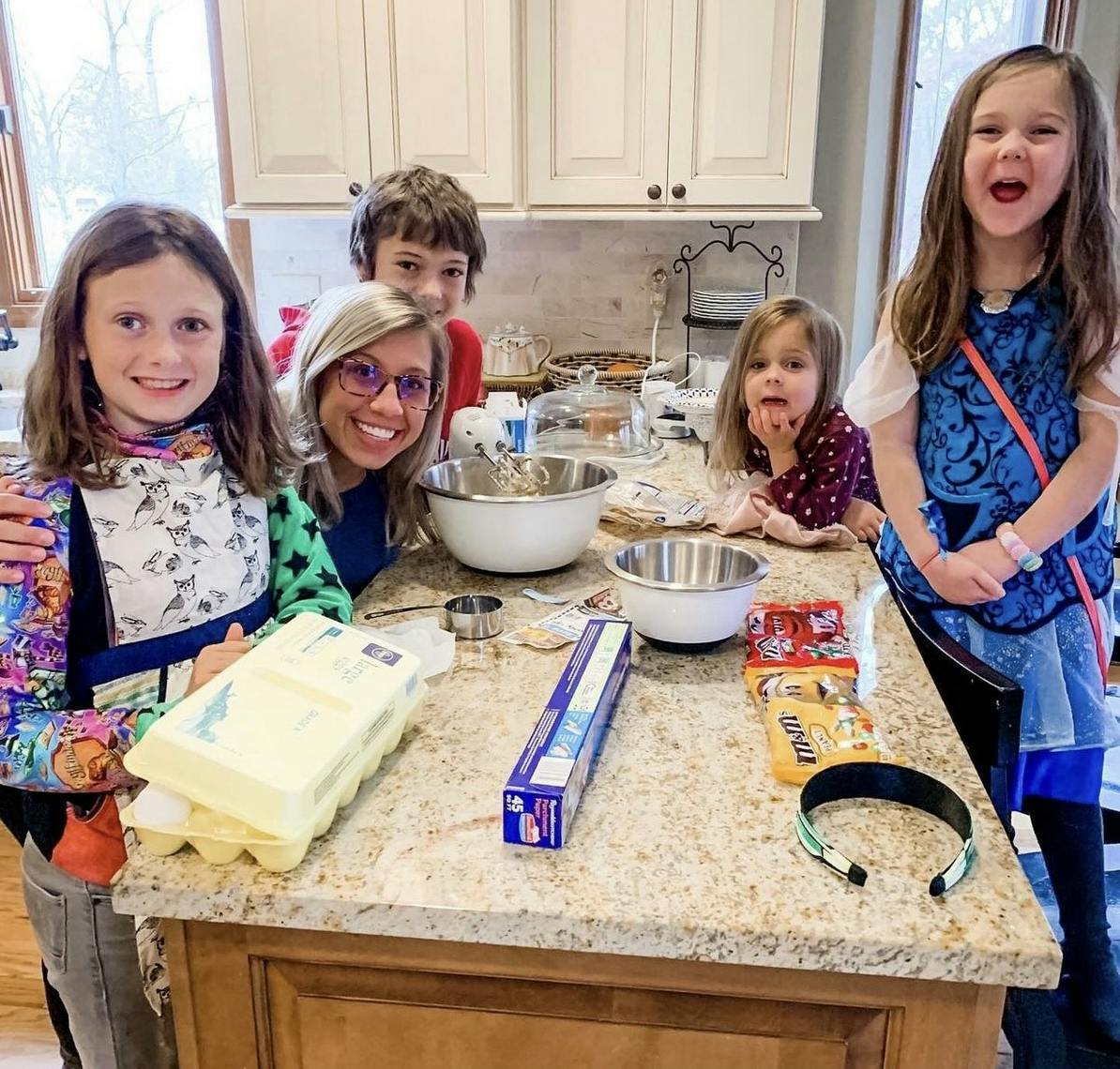 Adult and children in a kitchen with baking ingredients